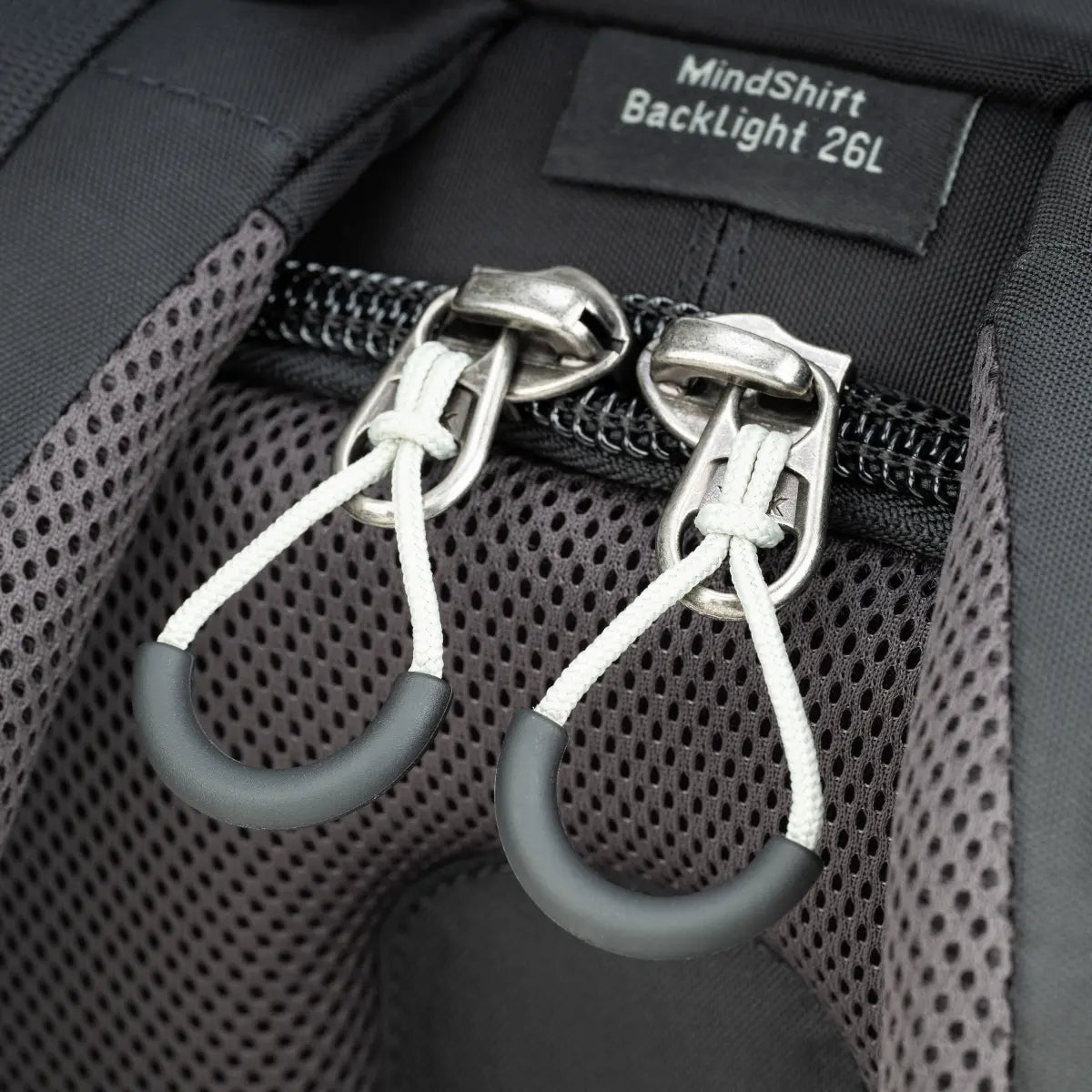 Close-up of a backpack with 'MindShift Backlight 26L' label and carabiners.