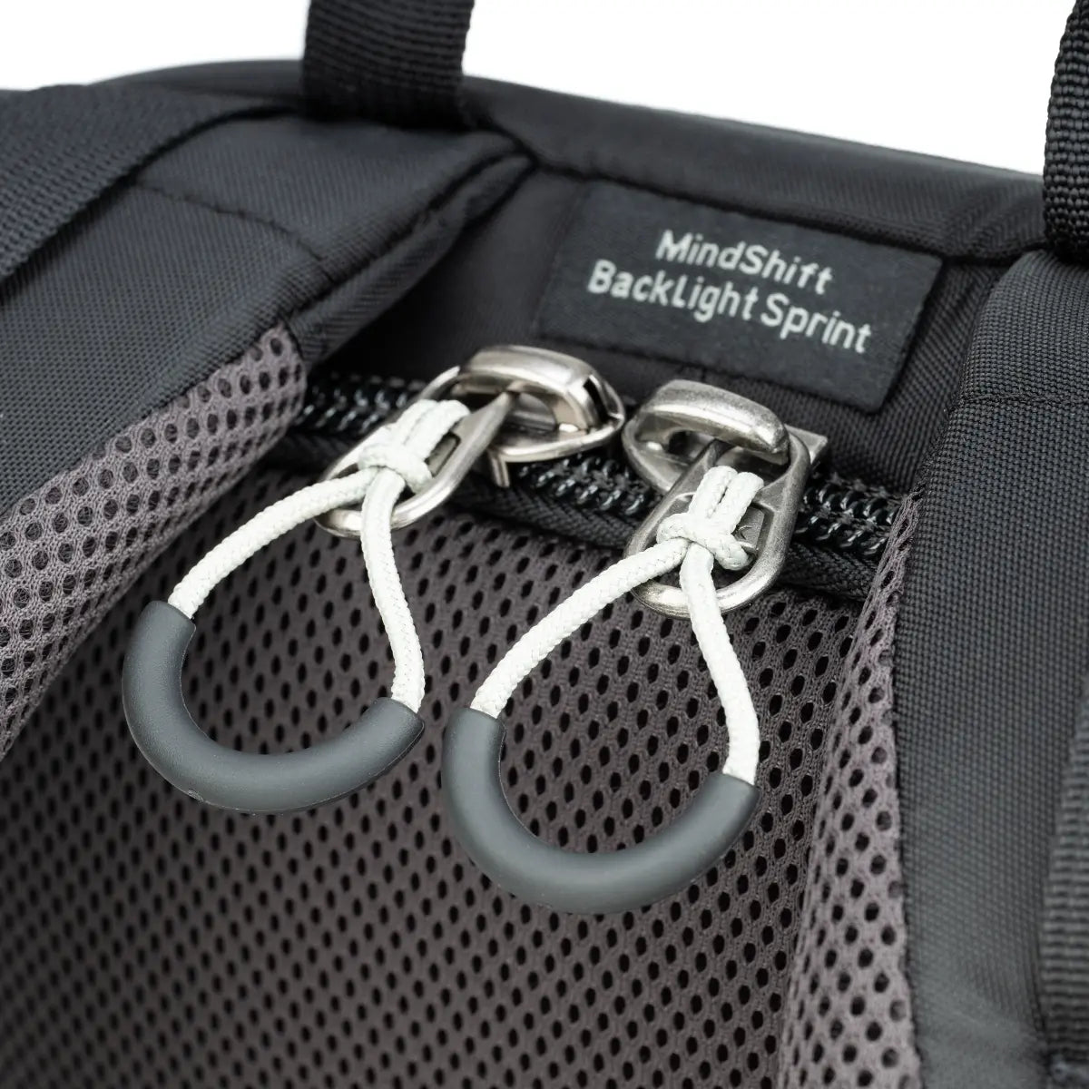 Close-up of a backpack with 'MindsShift BackLight Sprint' label and carabiners.