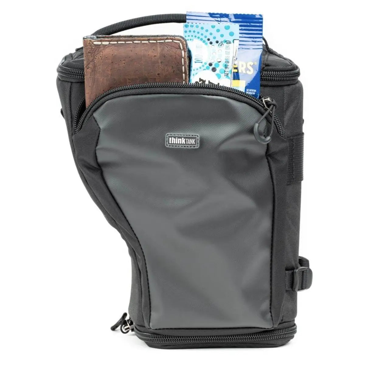 Gray Think Tank camera bag with a brown leather item and blue packaging on a white background