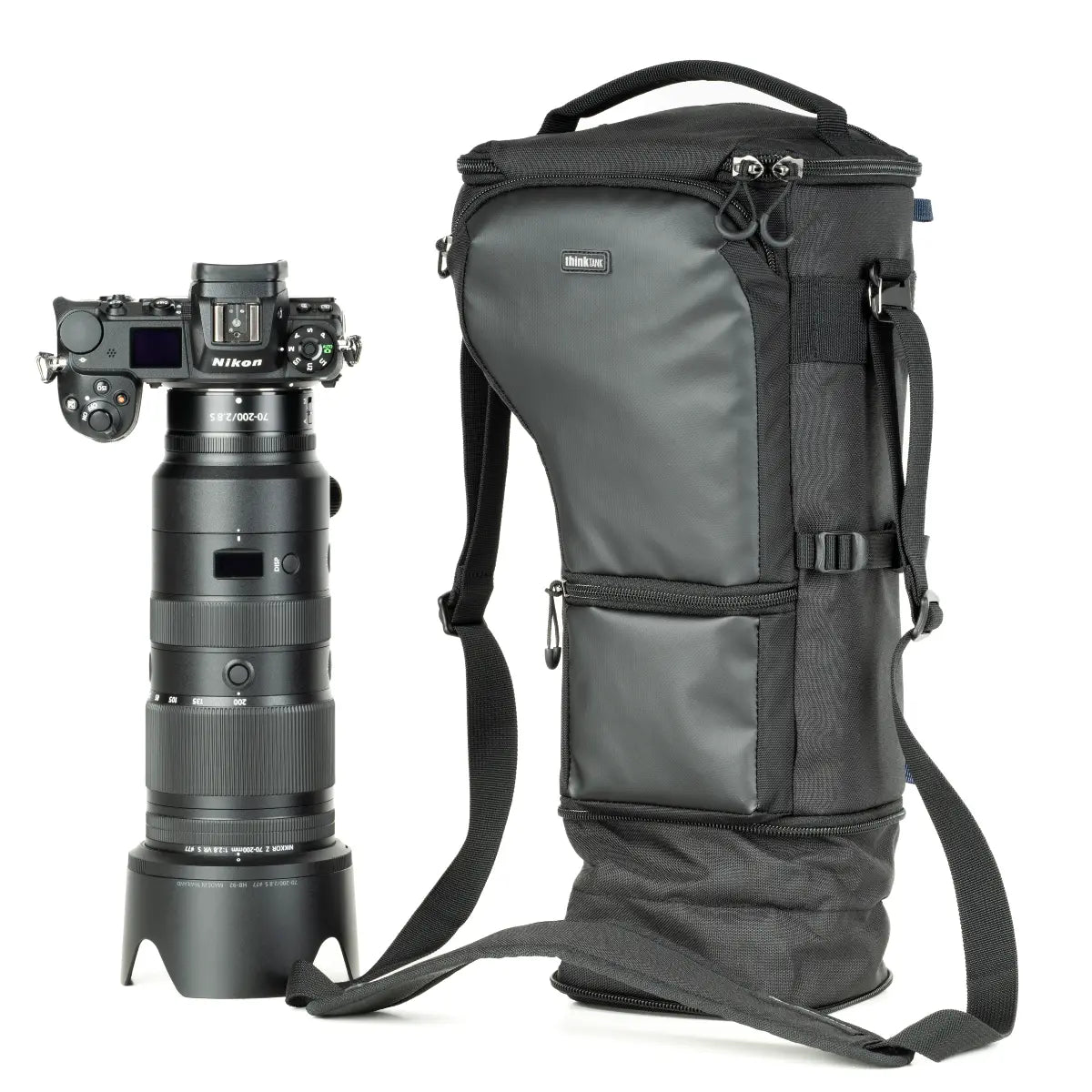 Camera with a long lens and a black camera backpack on a white background