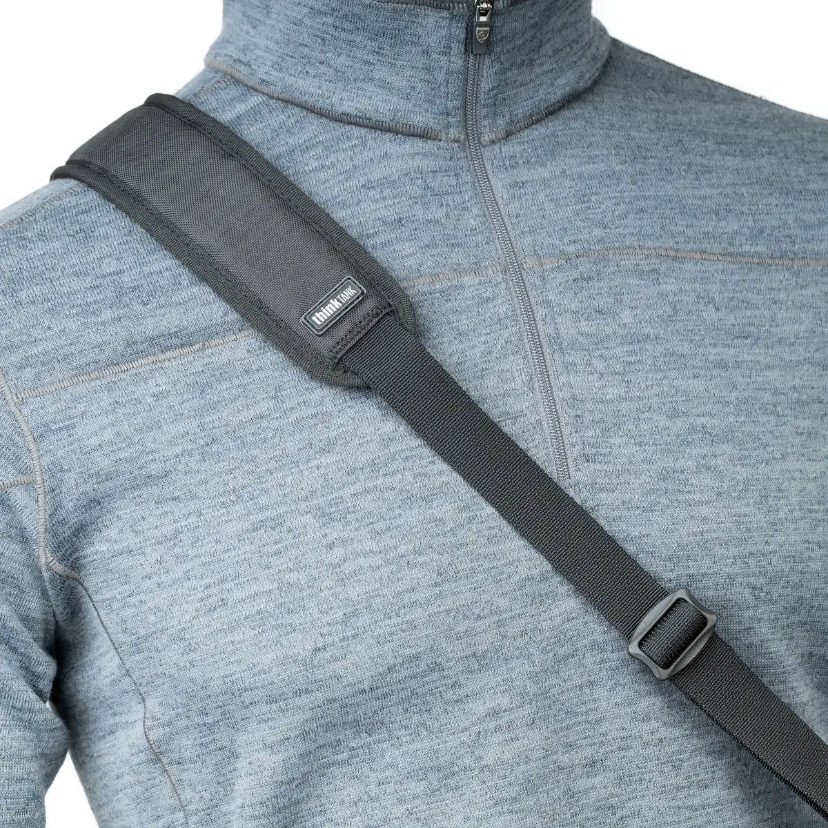 Gray sweater with a black shoulder strap and visible brand label on a white background