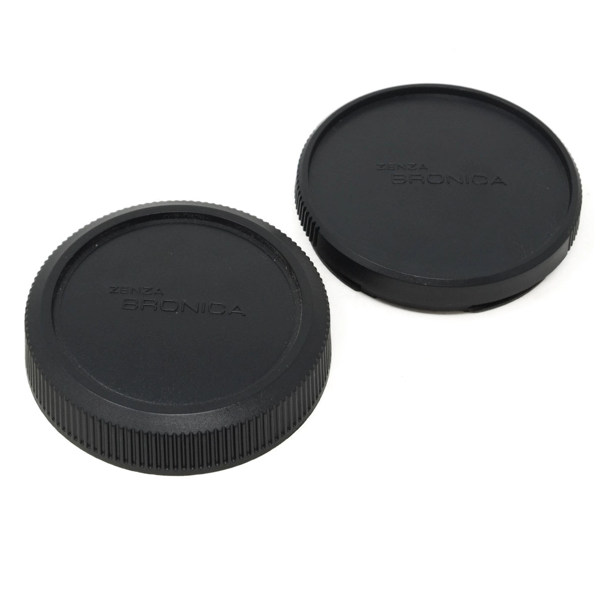 Two black camera lens caps with 'Zenza Bronica' branding on a white background