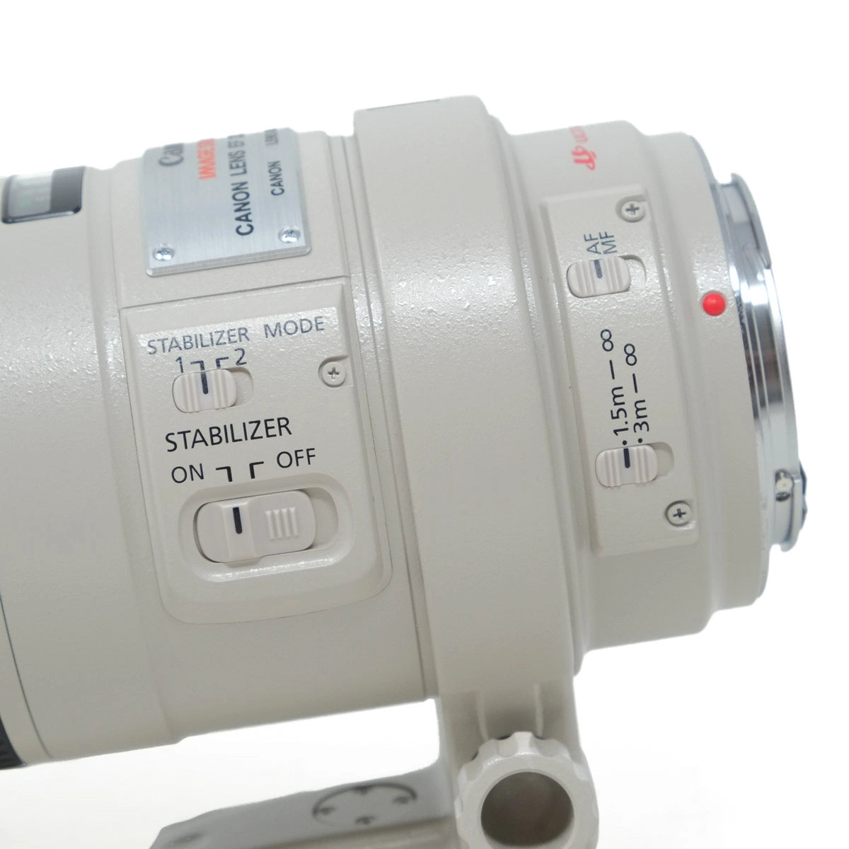 Close-up of a Canon camera lens with control buttons on a white background