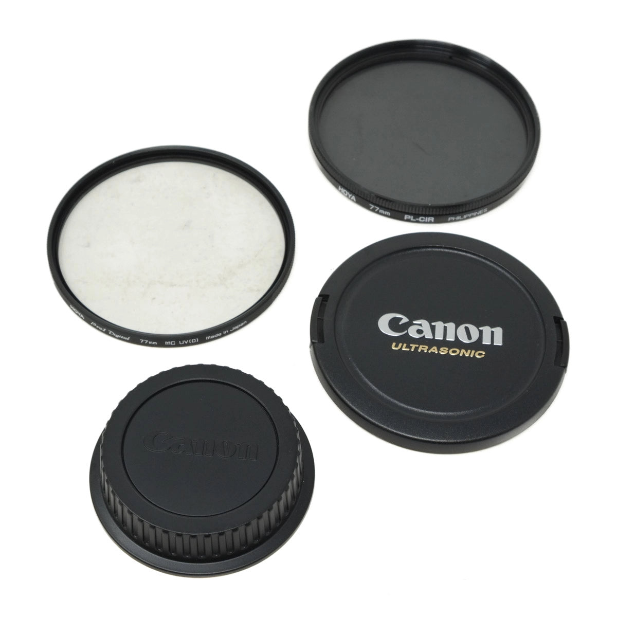 Set of Canon camera lens filters and caps on a white background