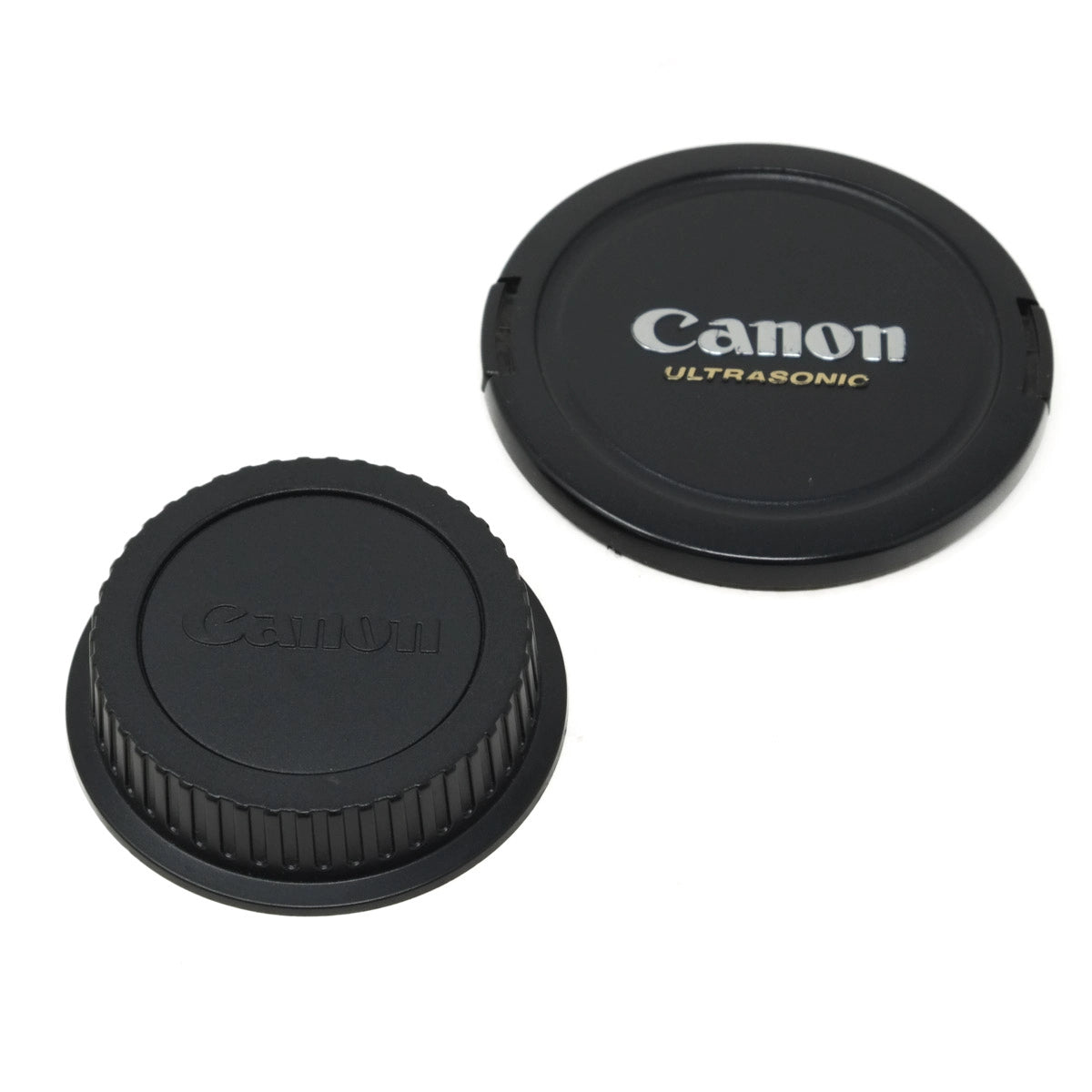 Two Canon lens caps on a white background