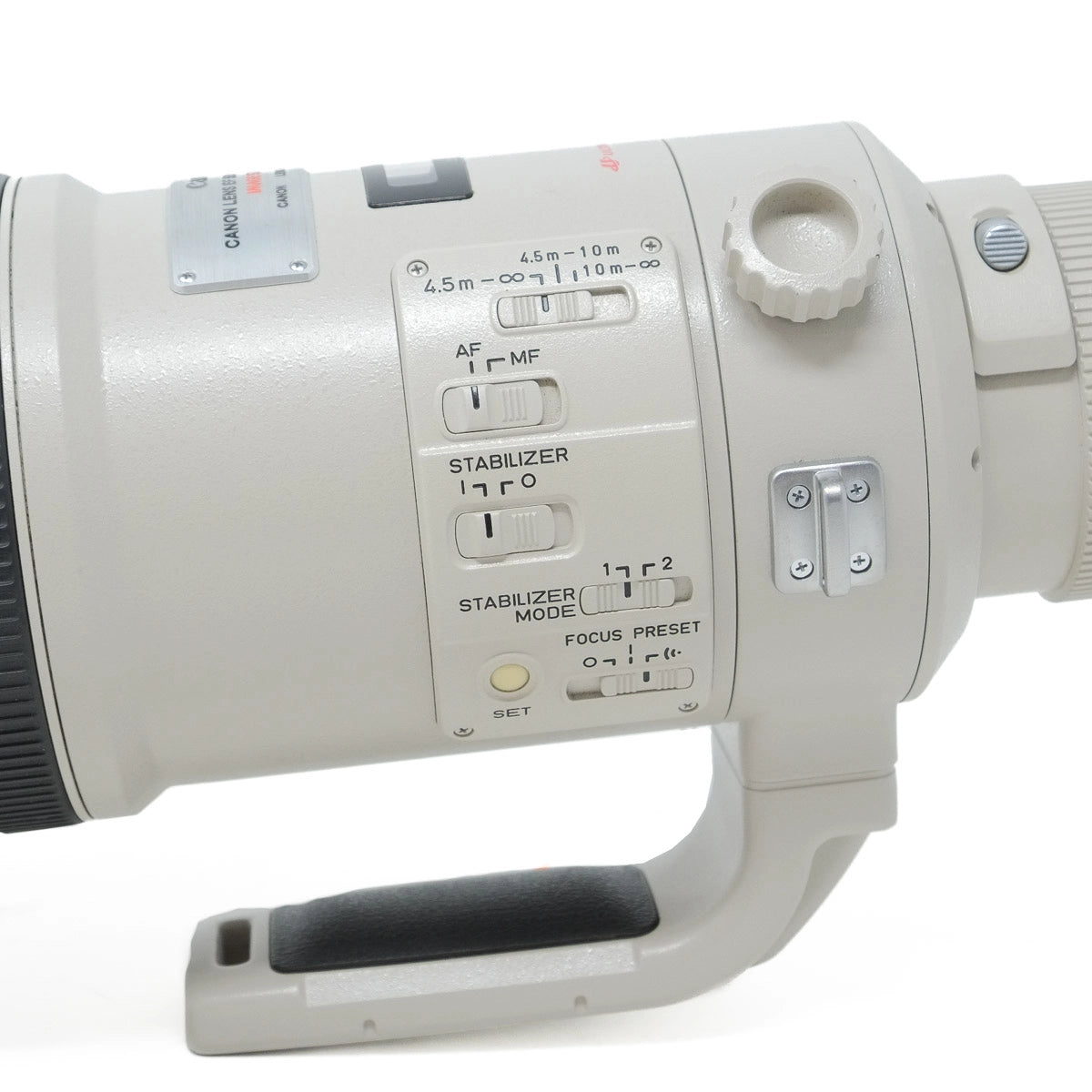 Close-up of a camera lens with control buttons on a white background