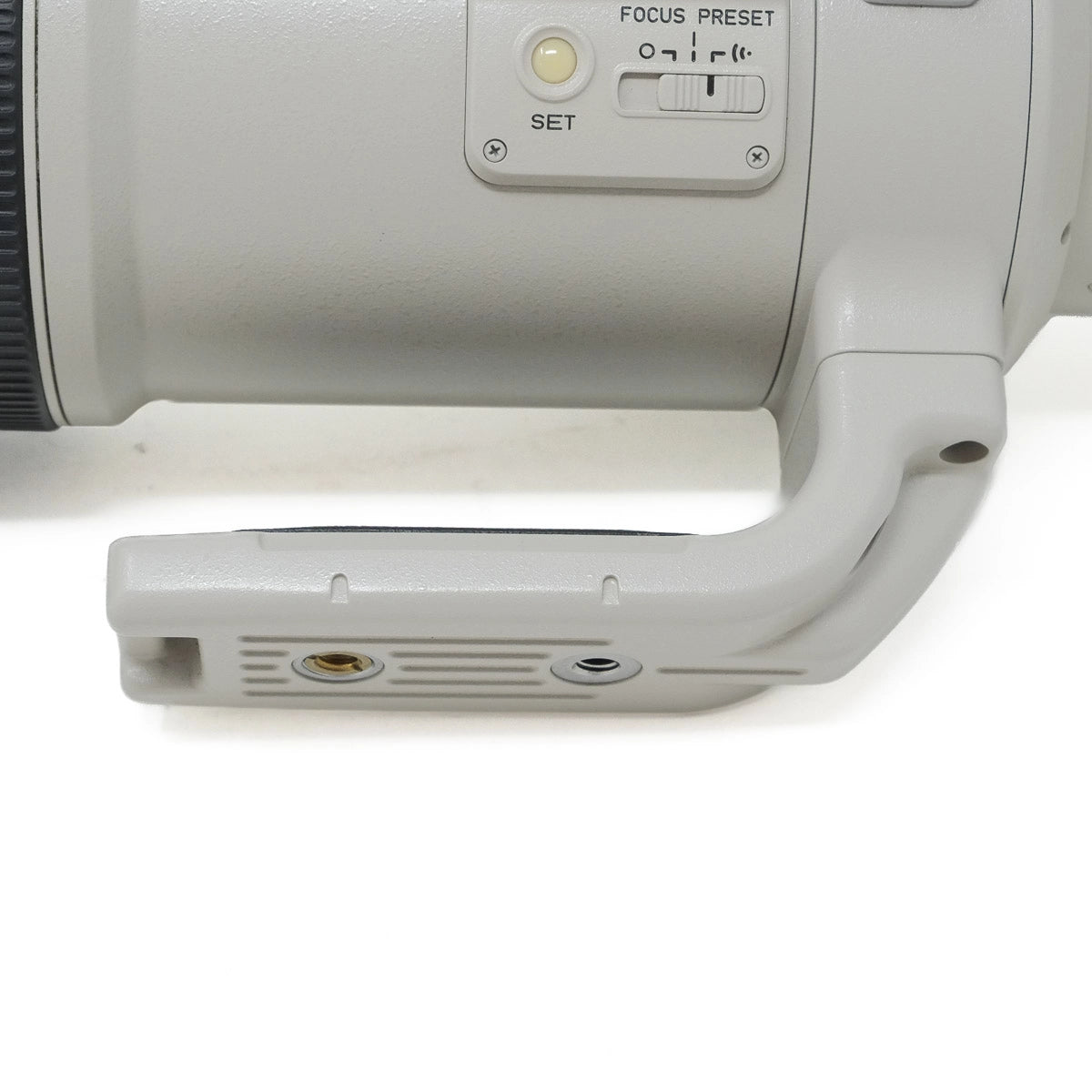 Close-up of a camera lens with control buttons on a white background