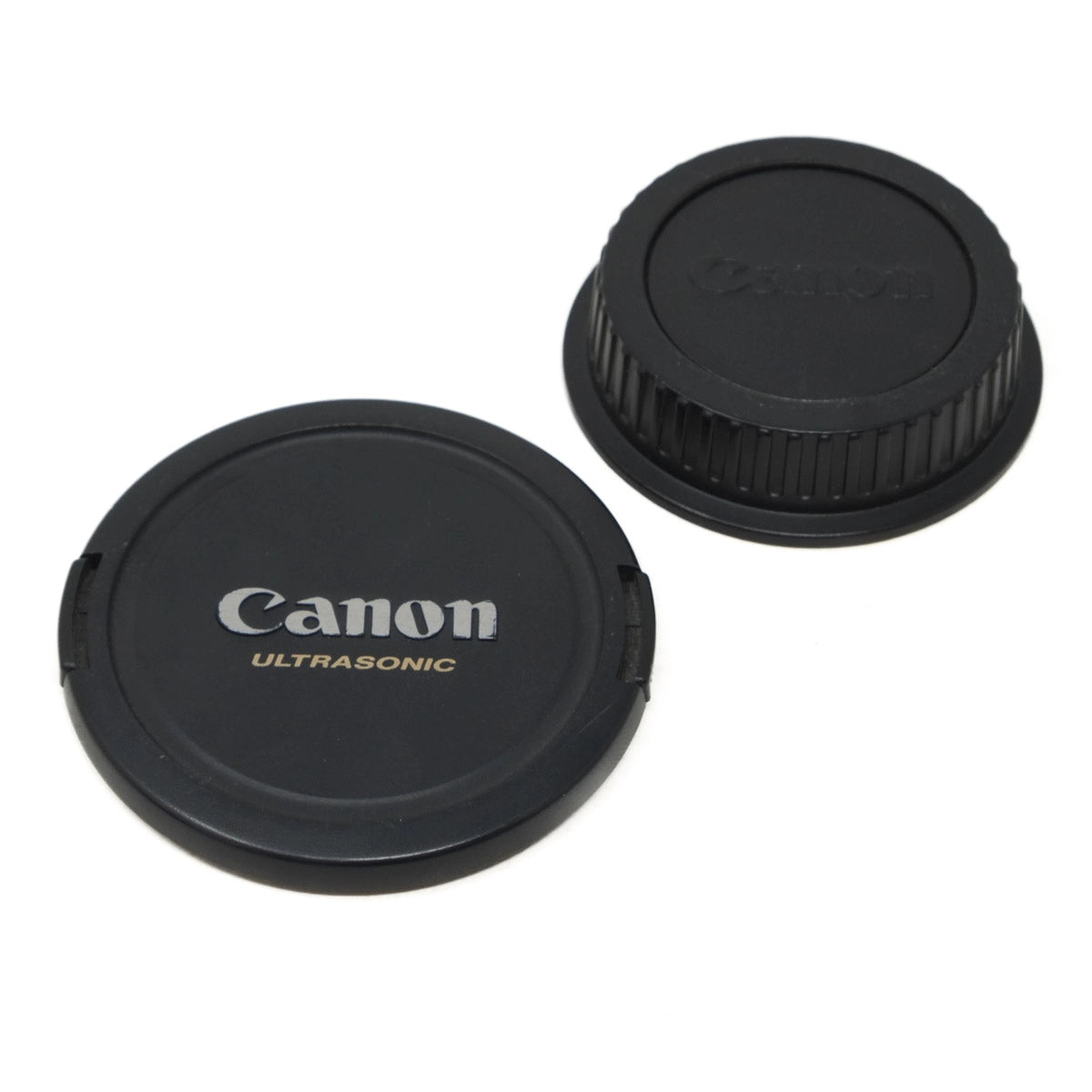 Two Canon lens caps on a white background