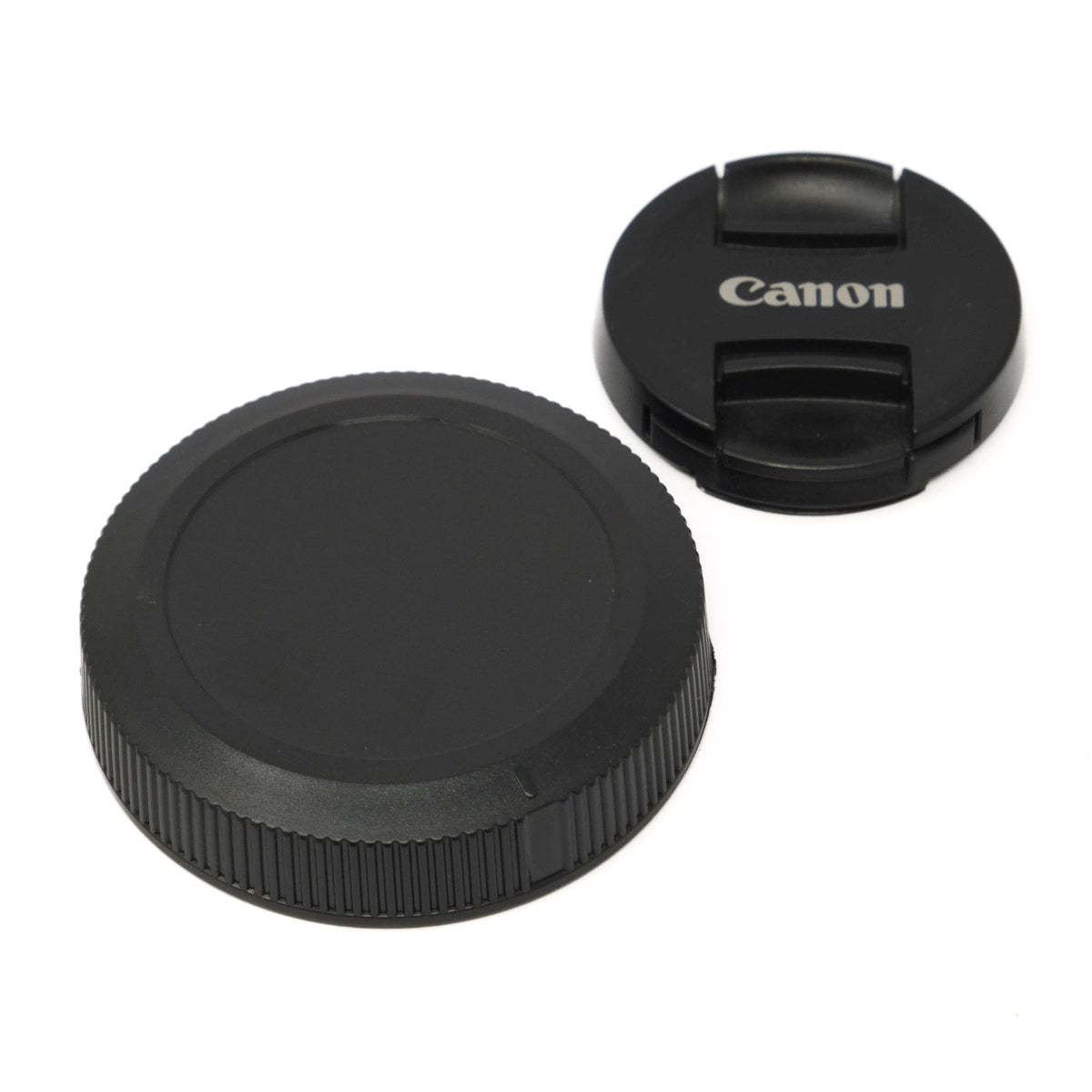 Two camera lens caps, one with Canon logo, on a white background