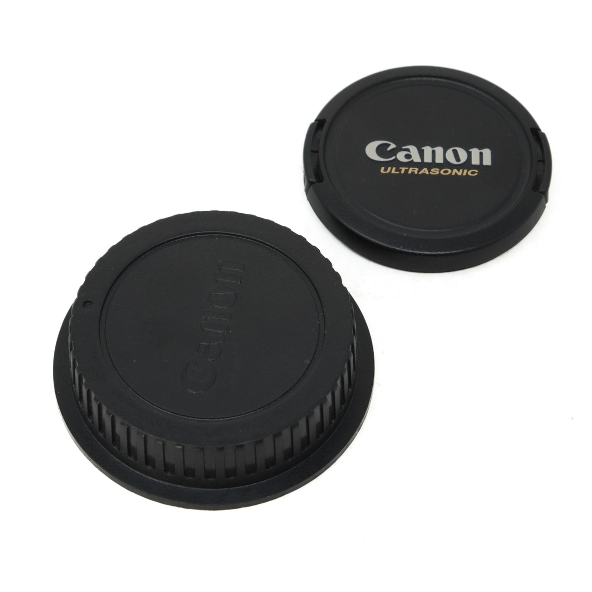 Two Canon lens caps on a white background