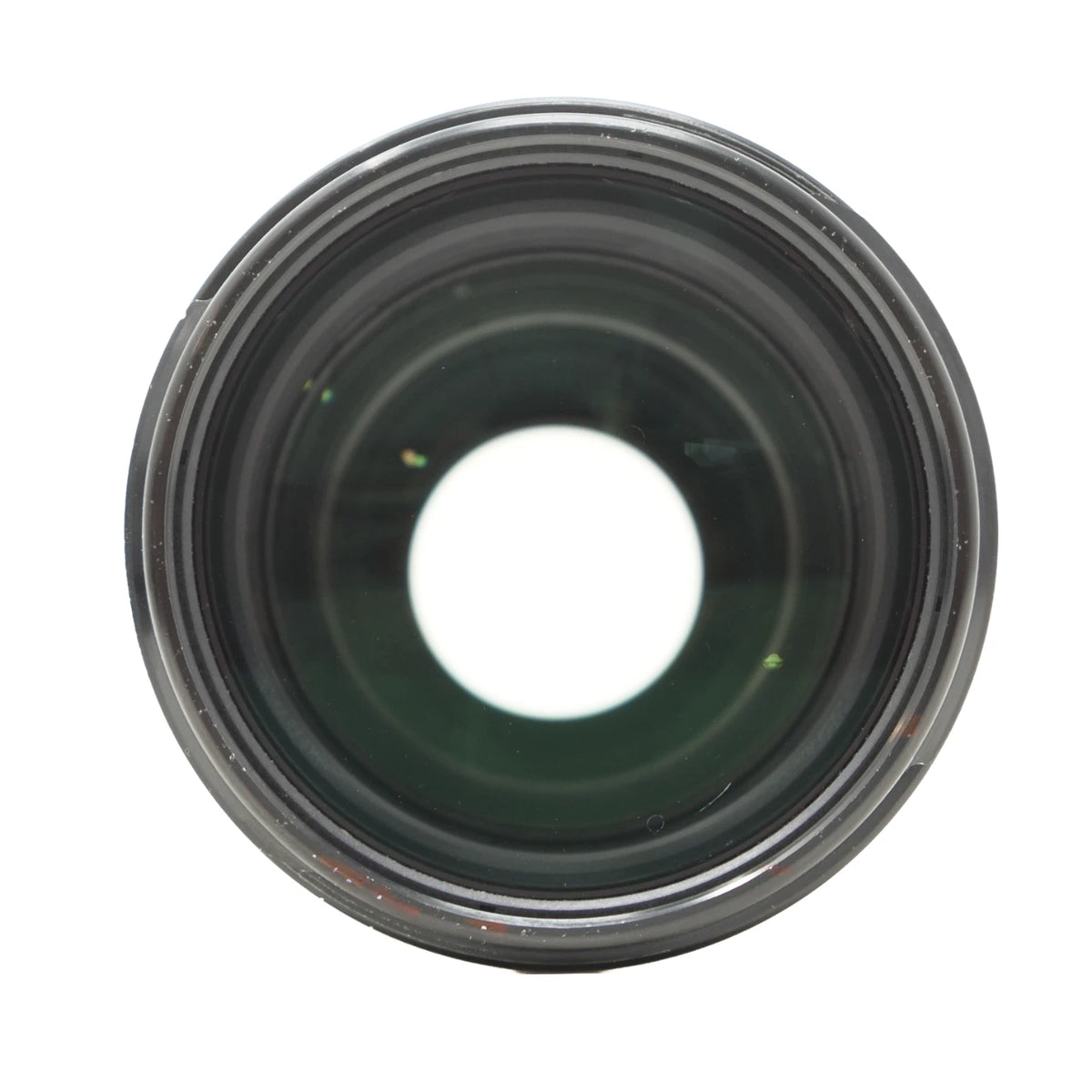 A close-up, top-down view of a camera lens with a dark gray metal rim and a dark green glass interior, centered on a solid white background.