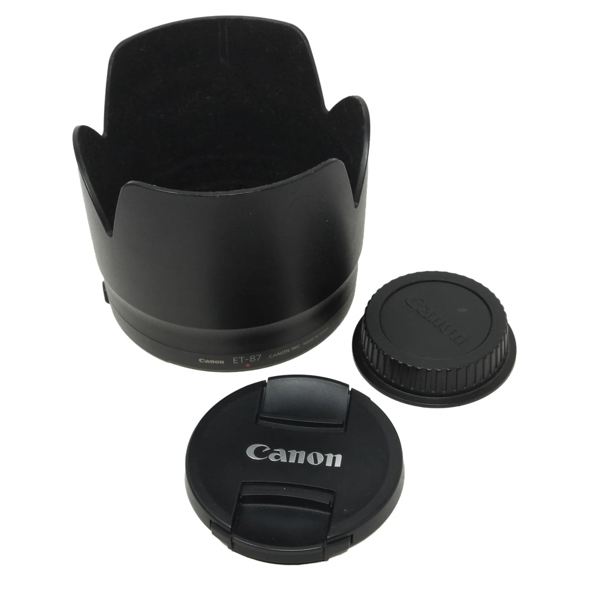 Canon camera lens accessory set including a black petal-shaped lens hood, a ribbed lens cap, and a front lens cover with the Canon logo, shown on a white background.