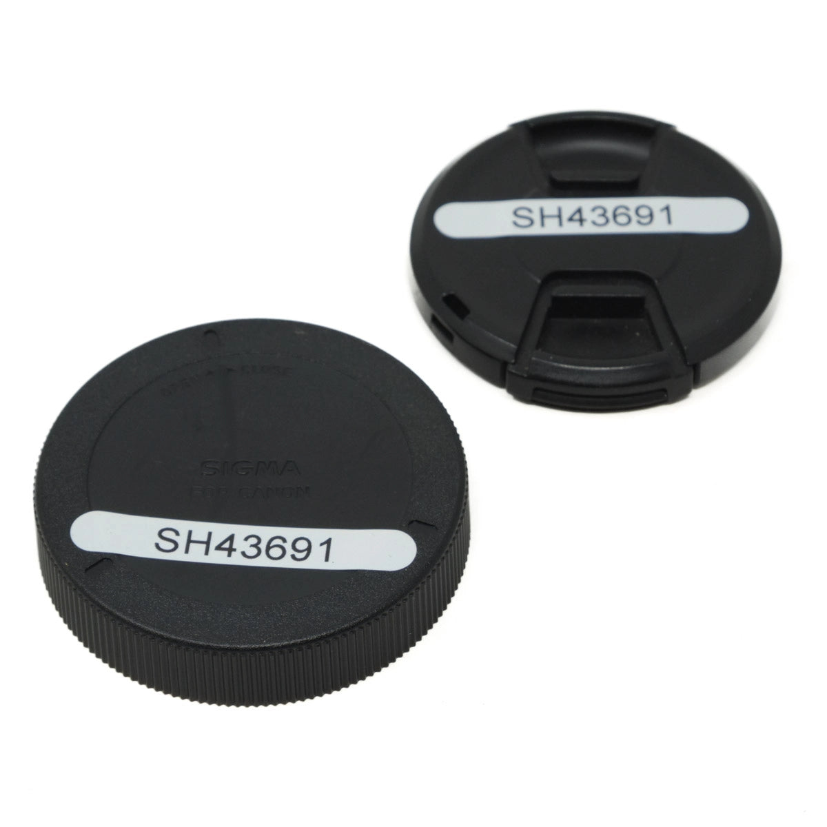 Two black lens caps with 'SH43691' label on a white background
