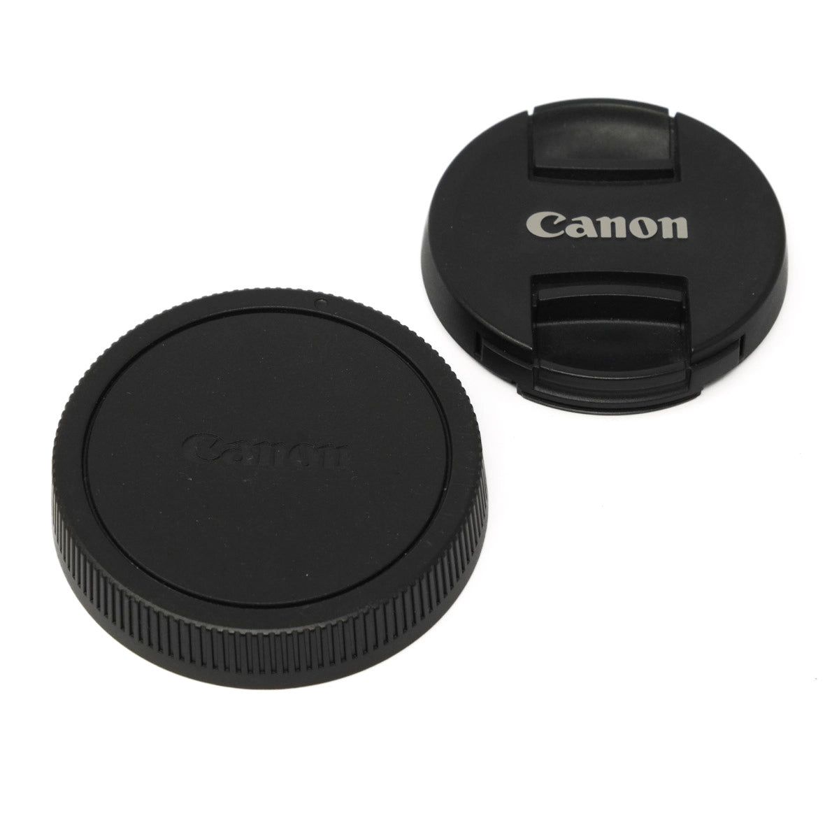 Two Canon lens caps on a white background