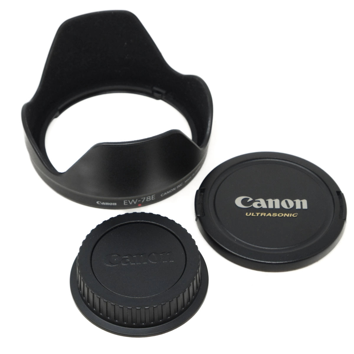 Canon lens cap, lens hood, and body cap on a white background