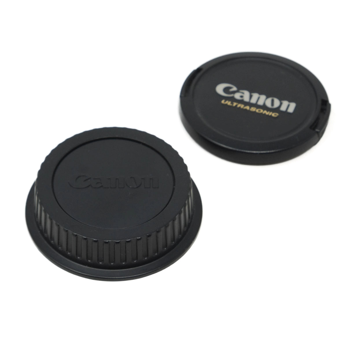 Two Canon lens caps on a white background