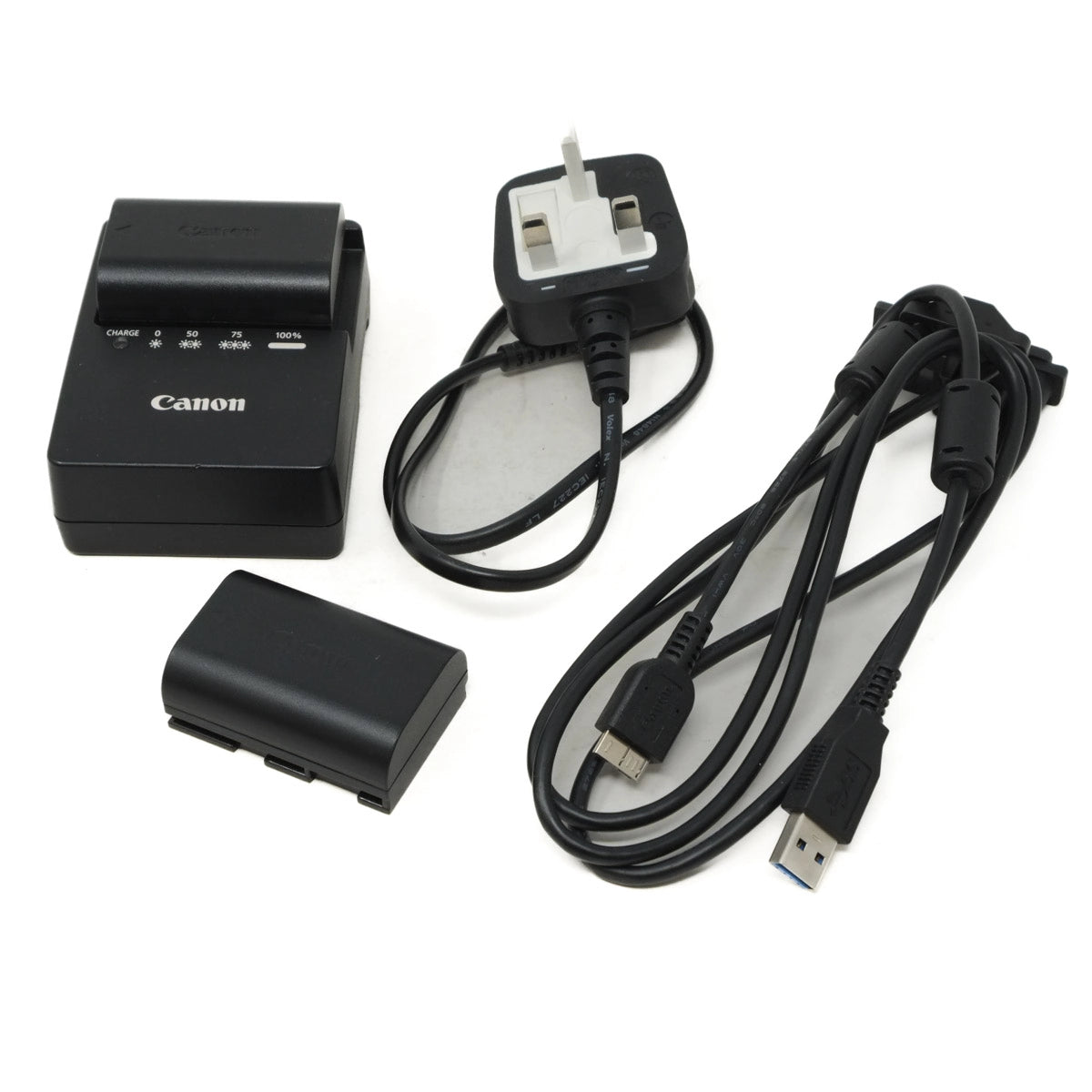 Canon battery charger set with battery, cable, and adapter on a white background