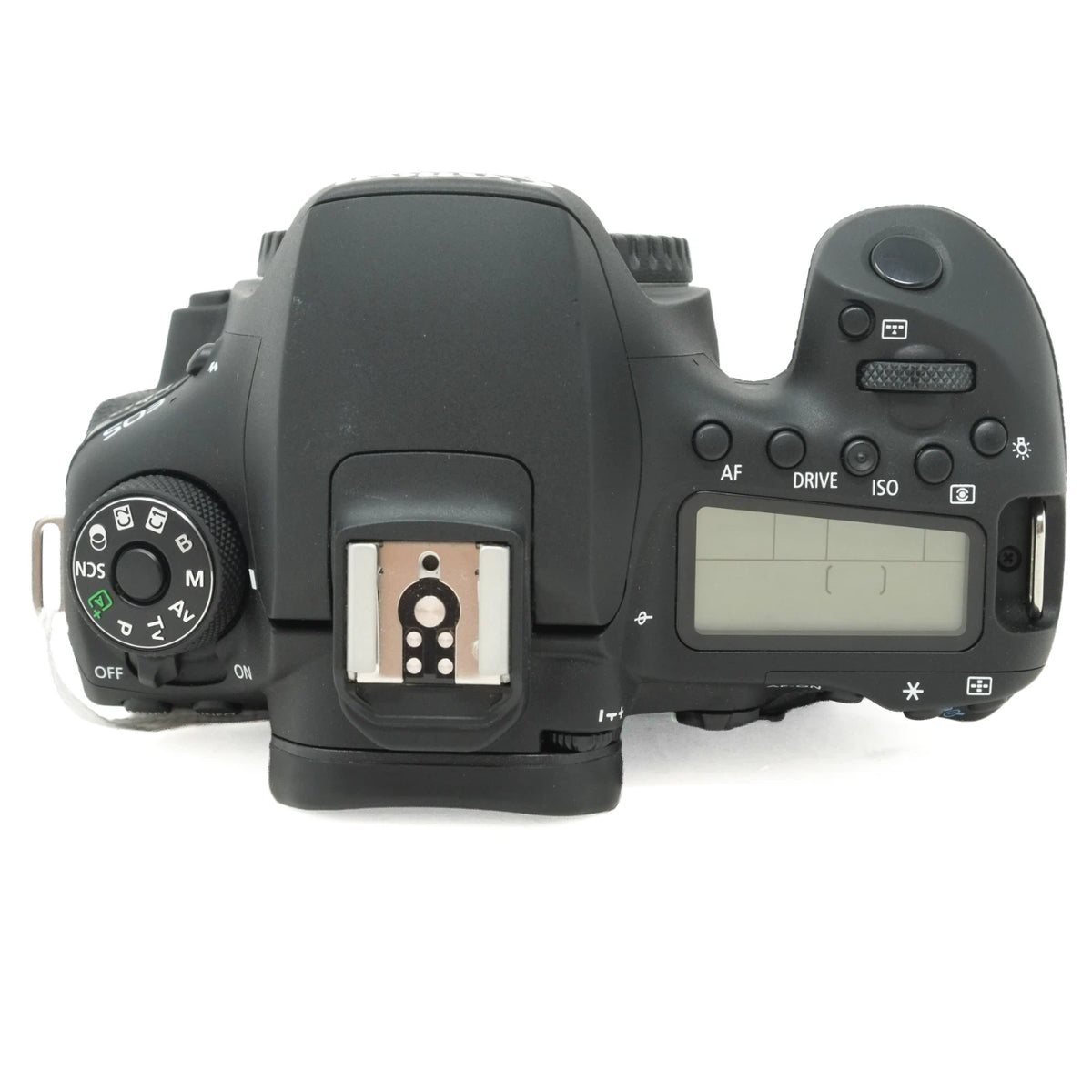 Top-down view of a black DSLR camera body with the hot shoe open, showing the mode dial on the left and control buttons on the right, photographed on a white background.