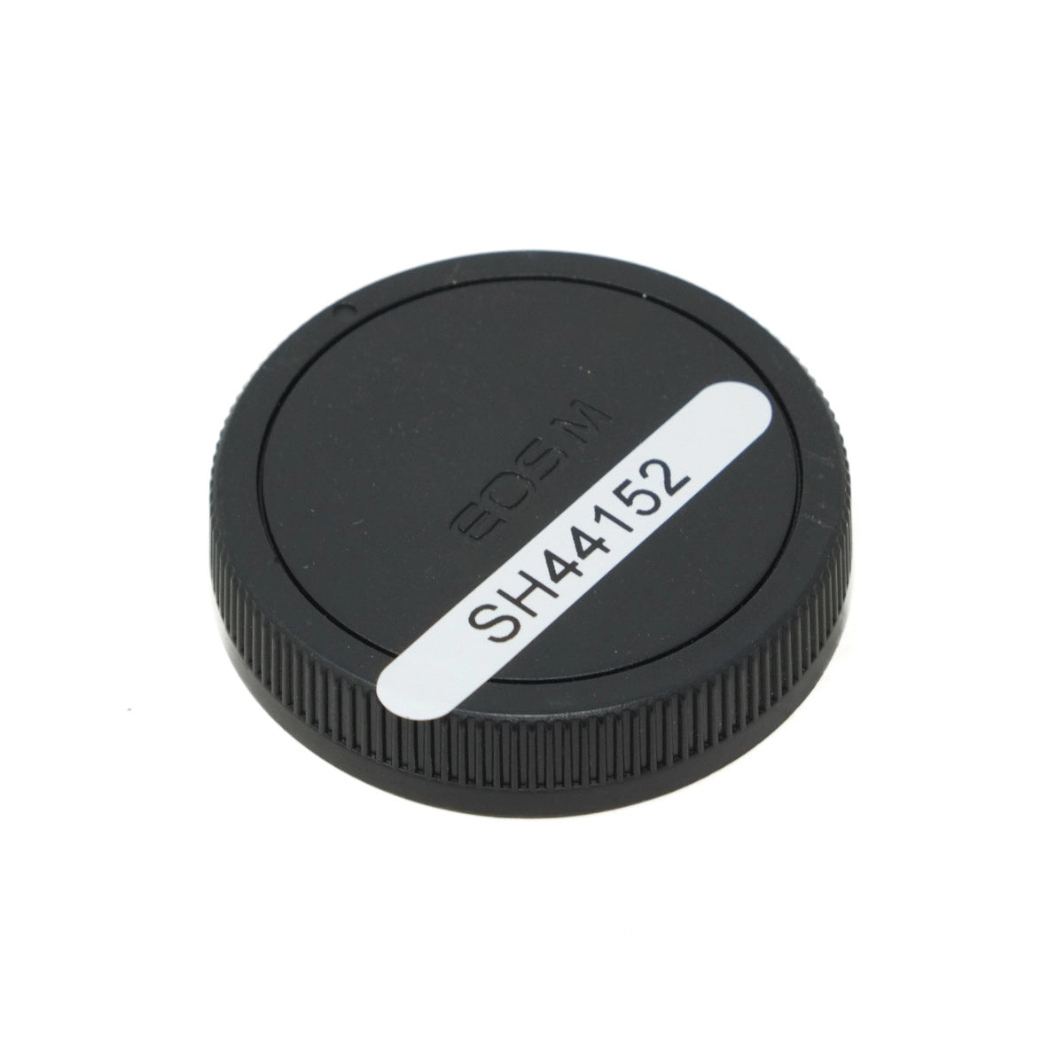 Black camera lens cap with white text on a white background