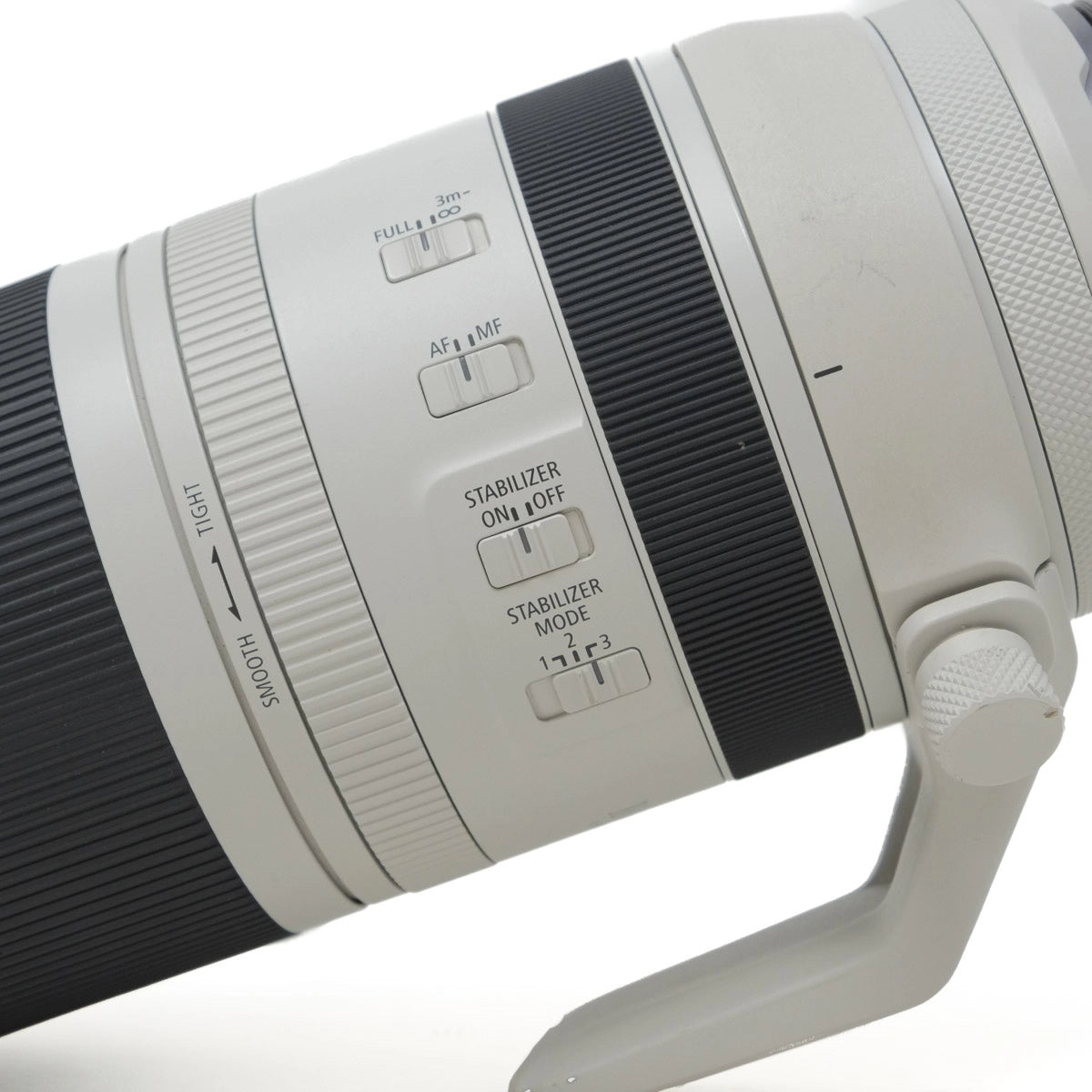 Close-up of a camera lens with control buttons on a white background