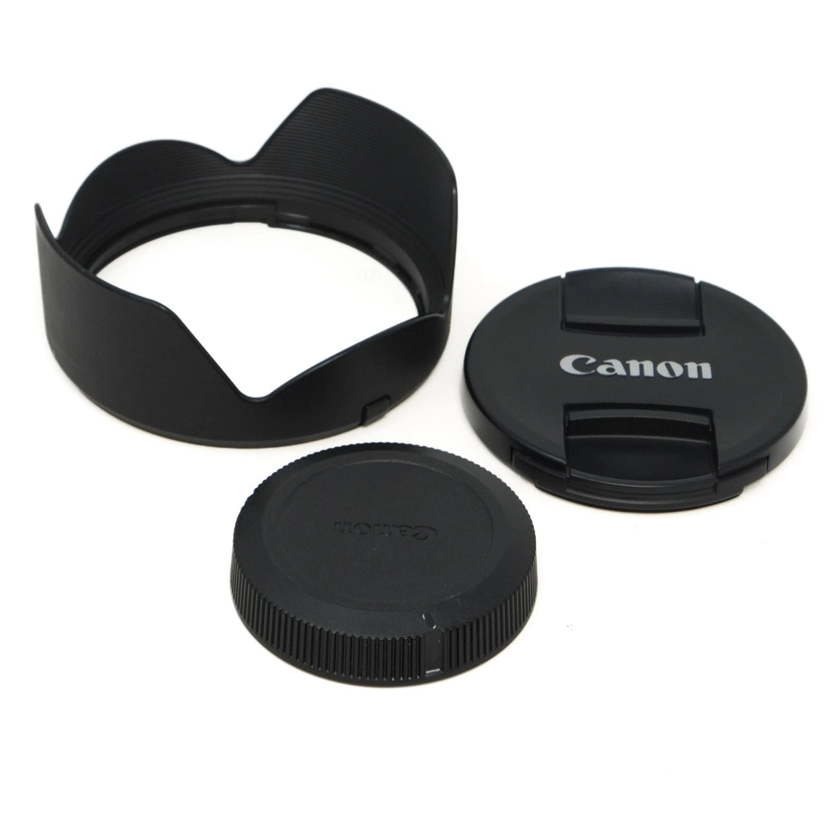 Camera lens accessories including a lens hood, front cap, and rear cap on a white background.