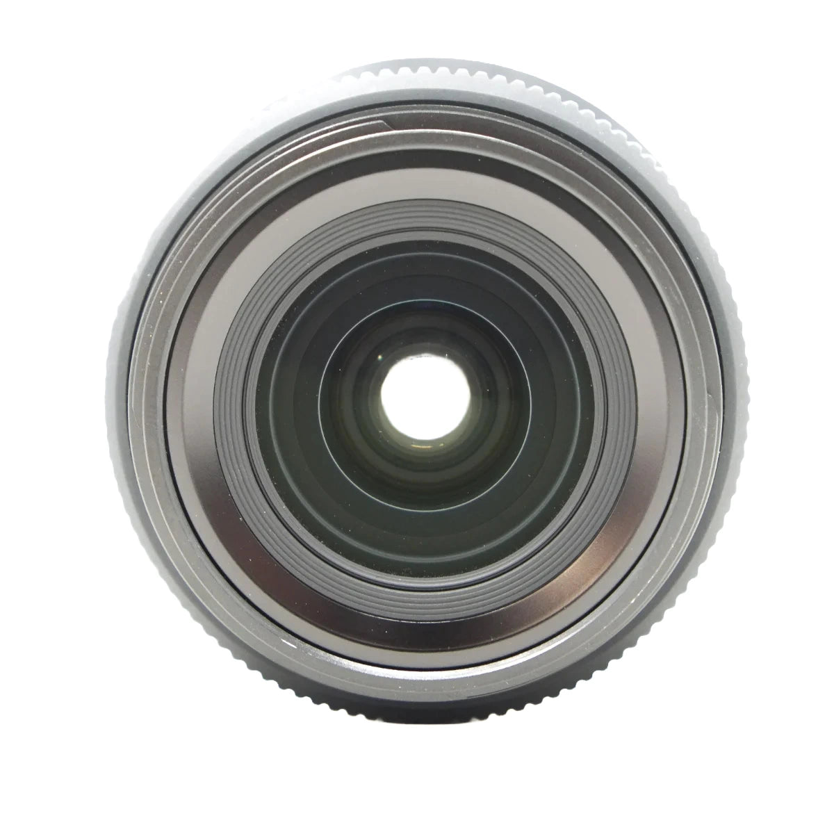 A close-up, top-down view of a camera lens showing its metallic silver outer ring, internal glass elements, and central aperture on a plain white background.