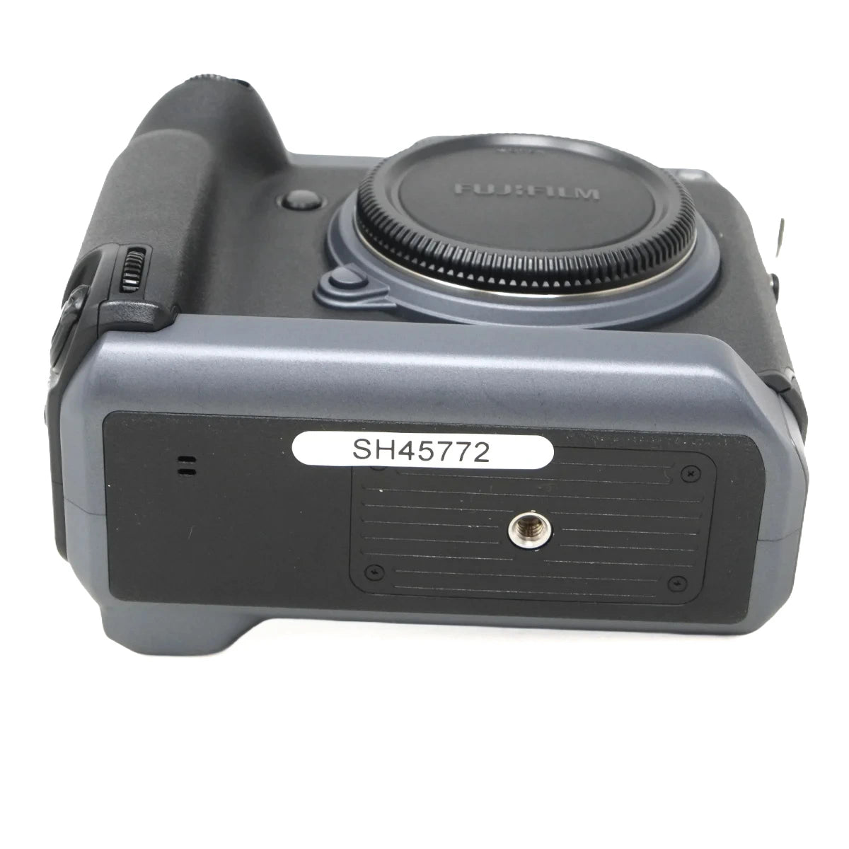 A Fujifilm GFX camera body with an attached battery grip, showing the back side with a white label reading 'SH45772'.