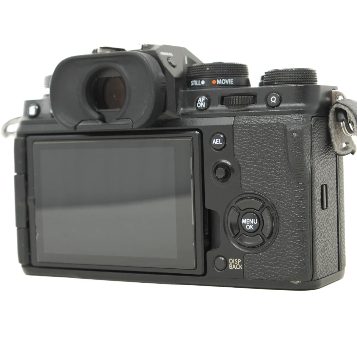 Black Fujifilm mirrorless camera body with rear LCD screen, top view showing dials and controls, photographed on a white background.