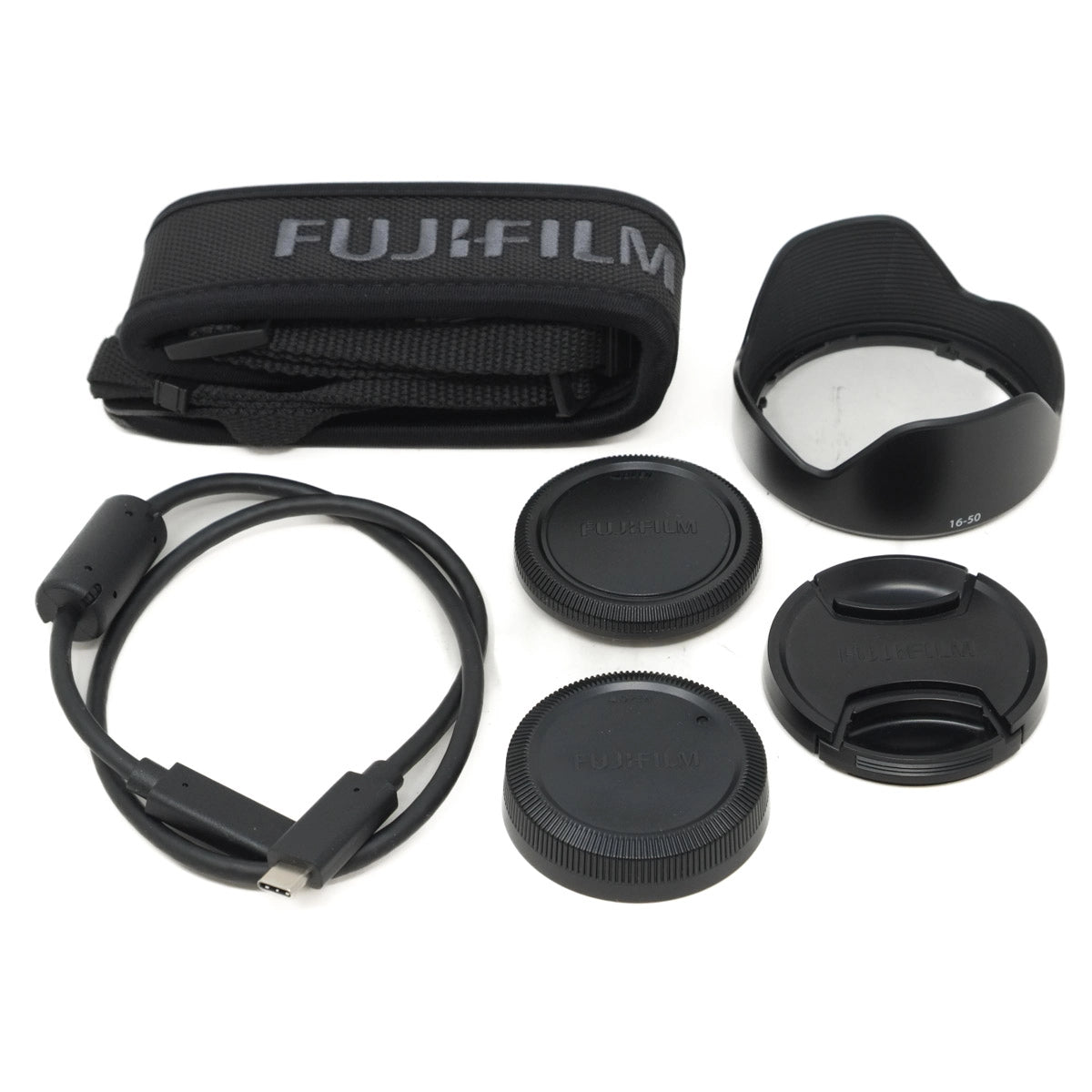 Camera lens accessories including a strap and lens caps on a white background