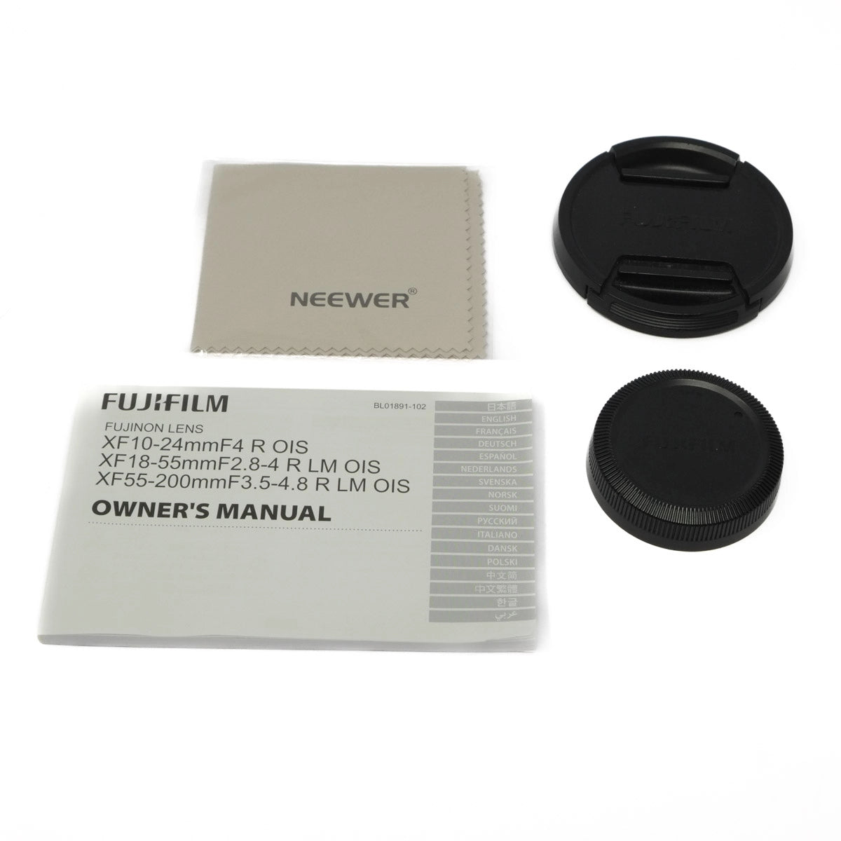 Camera lens accessories including lens caps, cleaning cloth, and owner's manual on a white background.