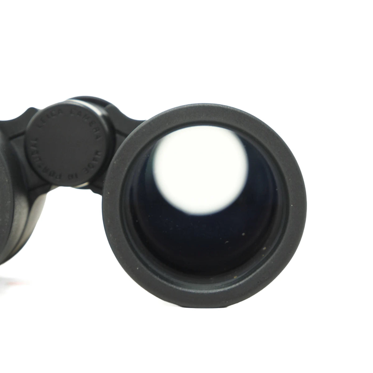 Close-up of a black binocular lens and hinge mechanism on a plain white background.