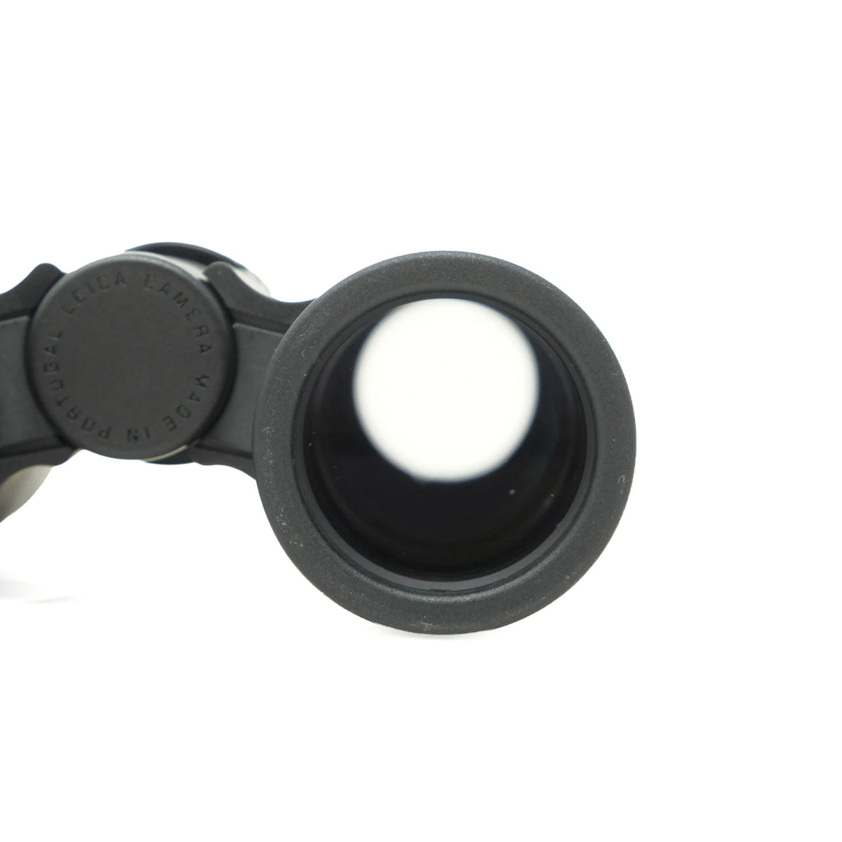Close-up of a black Binocular eyepiece lens with a textured rubberized edge and a circular adjustment knob, shown on a plain white background.