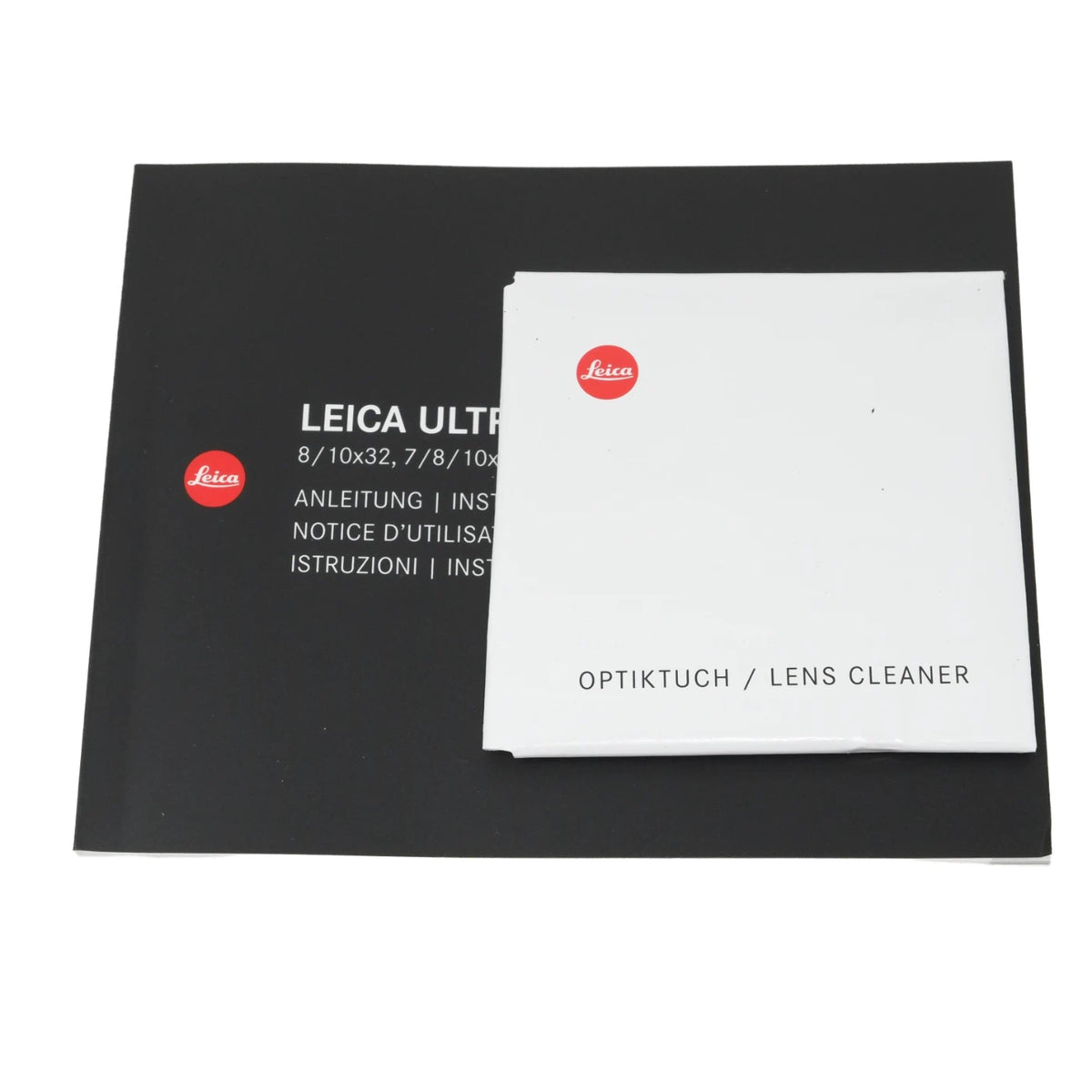 Leica Ultra lens cleaner kit showing the black instruction booklet and the white Optiktuach lens cleaner cloth with red Leica logos, on a plain white background.