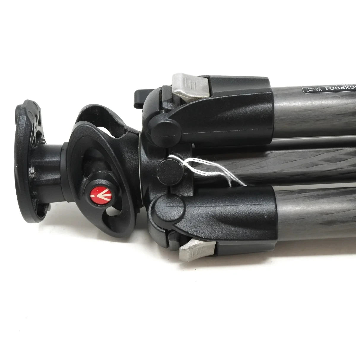 Close-up of a tripod leg section showing the black and dark gray carbon-fiber tubes, adjustment knobs, and a red logo button on the head, photographed on a white background.