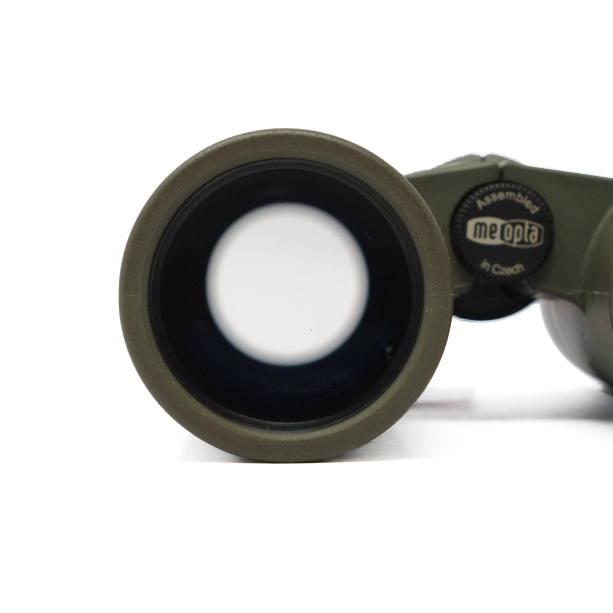 Close-up of a green binoculars lens with 'meopta' branding on a white background