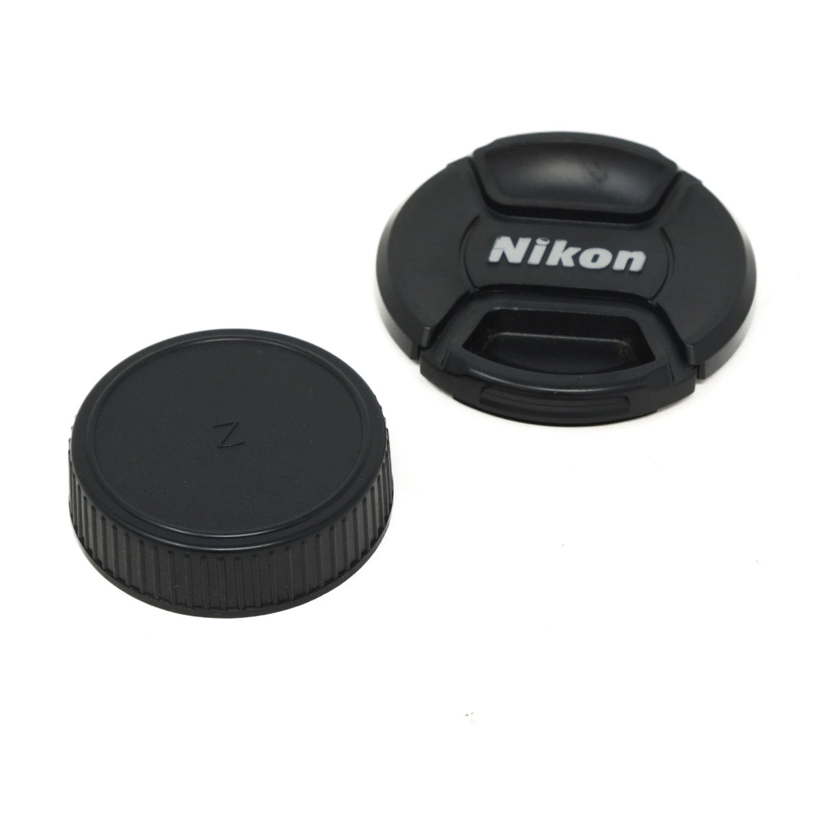 Two black camera lens caps, one with a Nikon logo, on a white background.