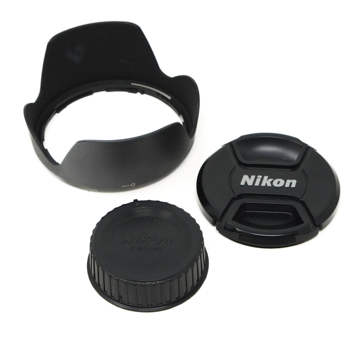 Camera lens accessories including a lens hood, rear and front lens caps on a white background.