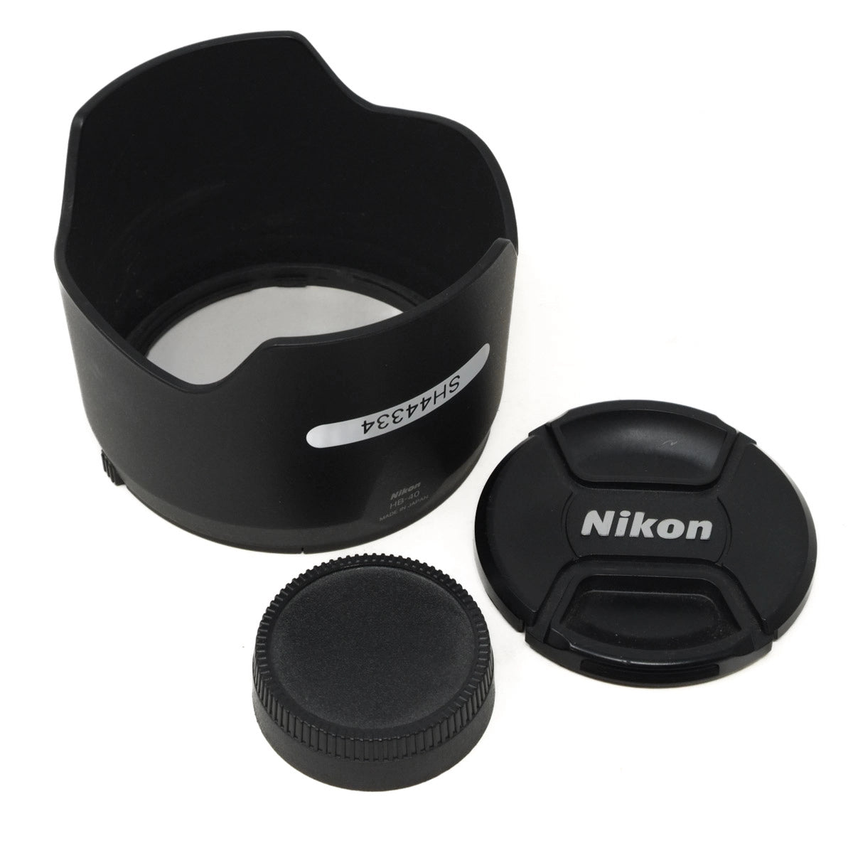 Camera lens hood, lens cap, and Nikon logo on a white background