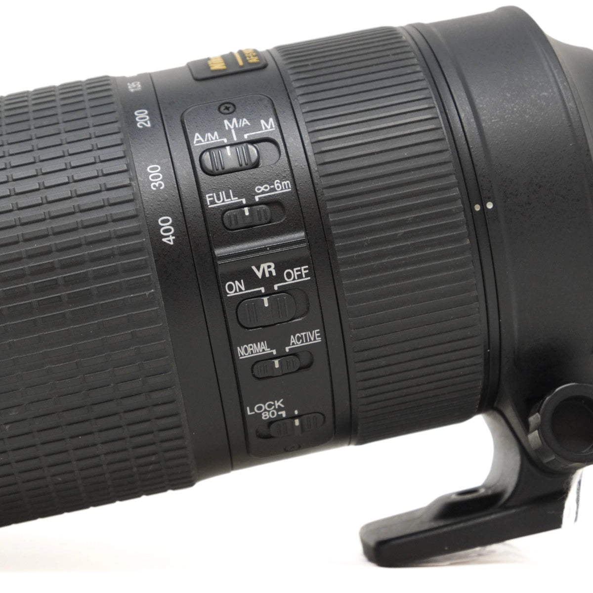 Close-up of a camera lens with control buttons on a white background