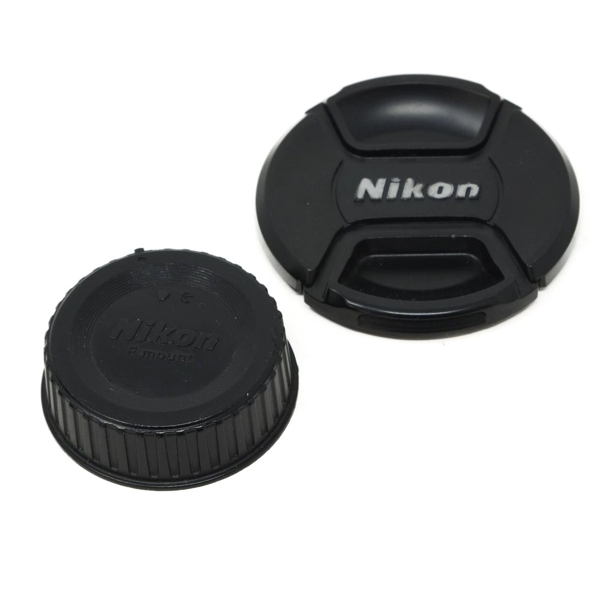 Two black Nikon lens caps on a white background