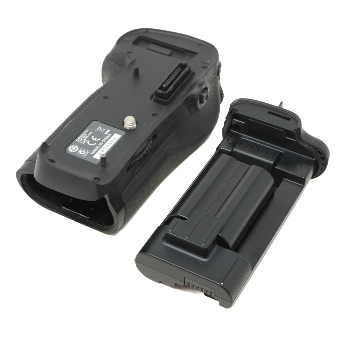 A black camera battery grip and matching battery charger/dock station shown on a plain white background.
