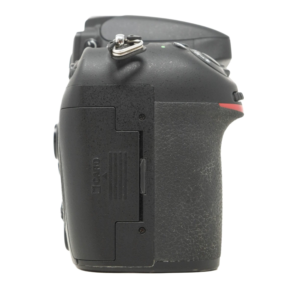 A close-up side view of a black DSLR camera body, showing the textured grip, hot shoe, card slot cover, and a small red accent line on a white background.