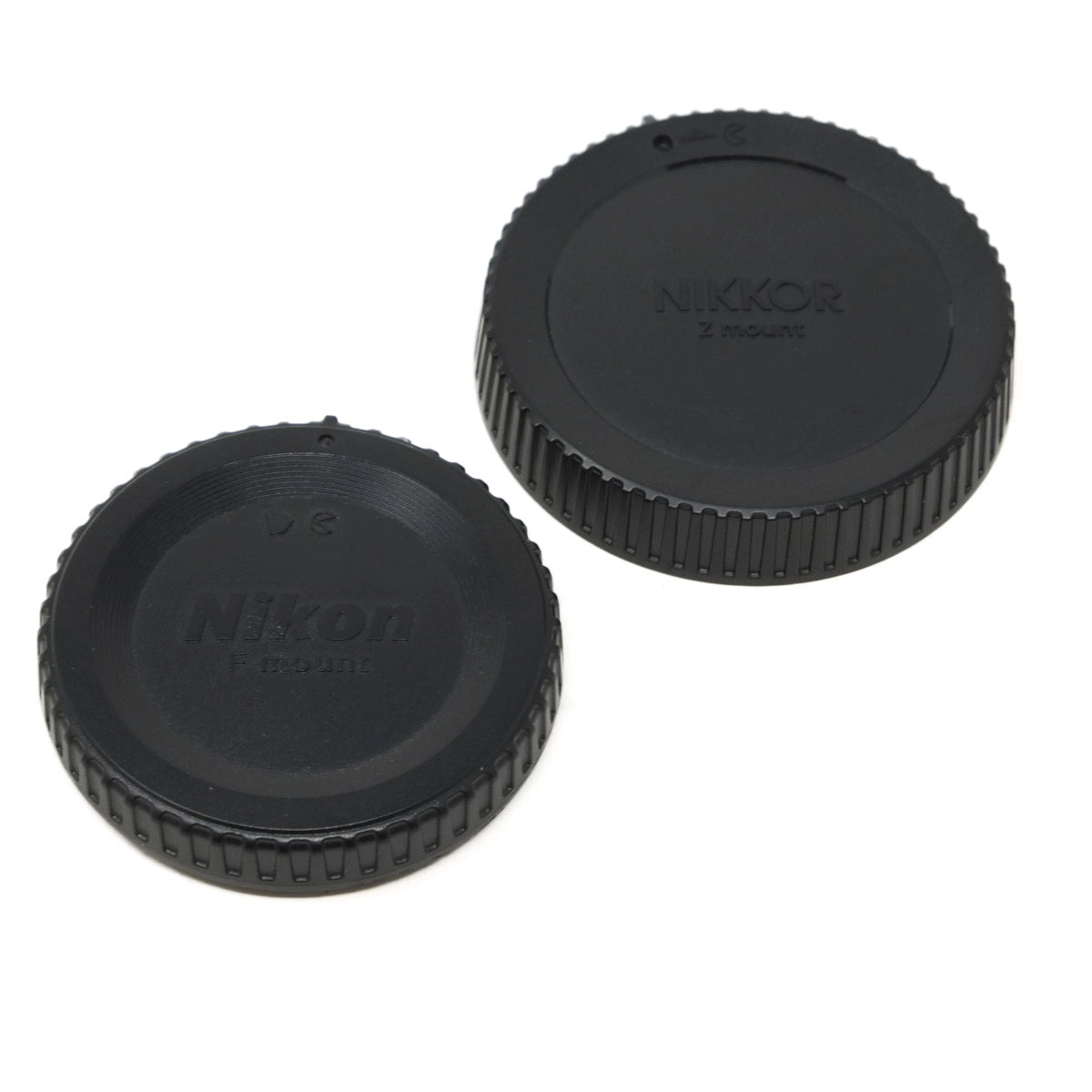 Two black Nikon lens caps on a white background