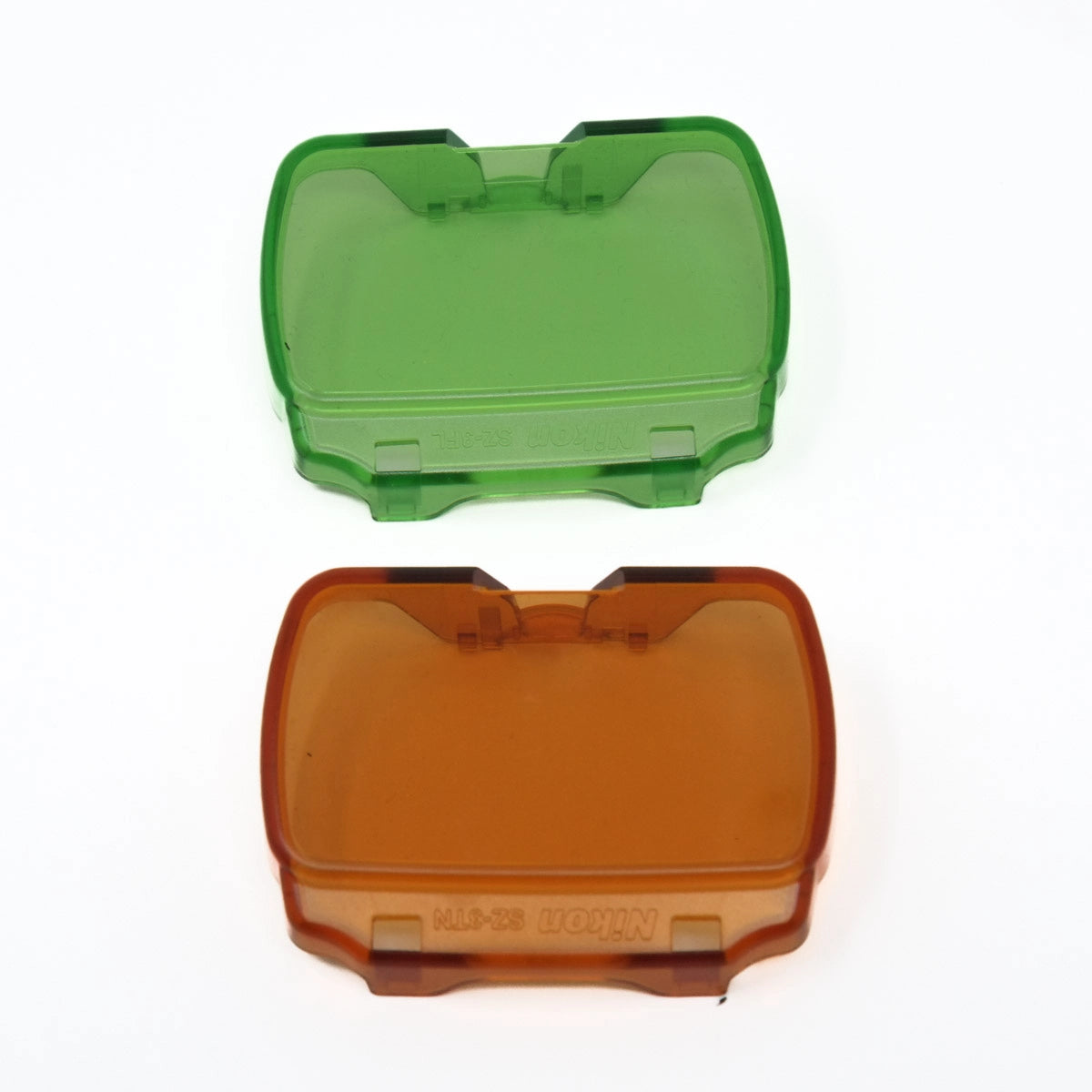 Green and orange plastic flash gels on a white background