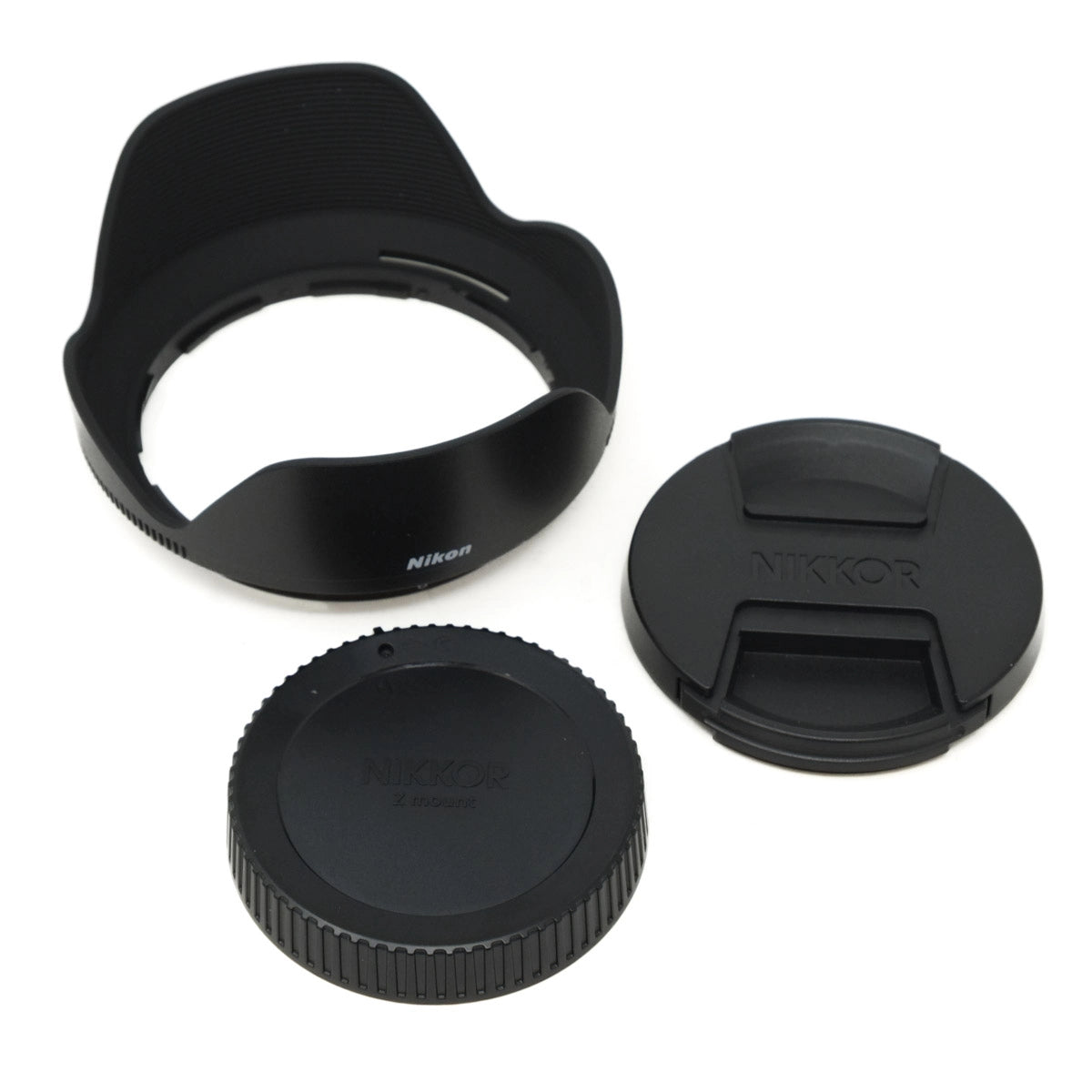 Nikon lens hood, front cap, and rear cap on a white background