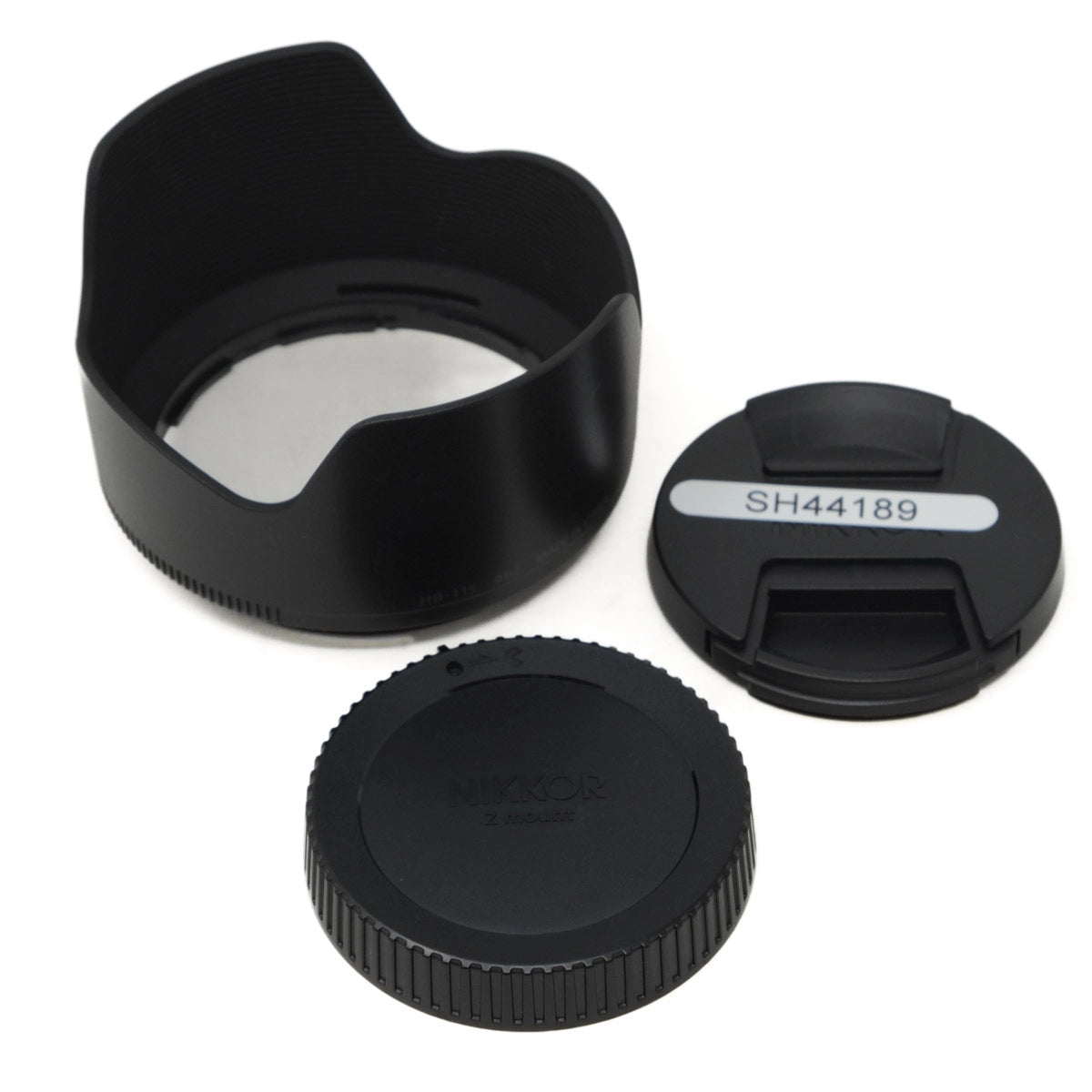 Camera lens hood, front cap, and rear cap on a white background