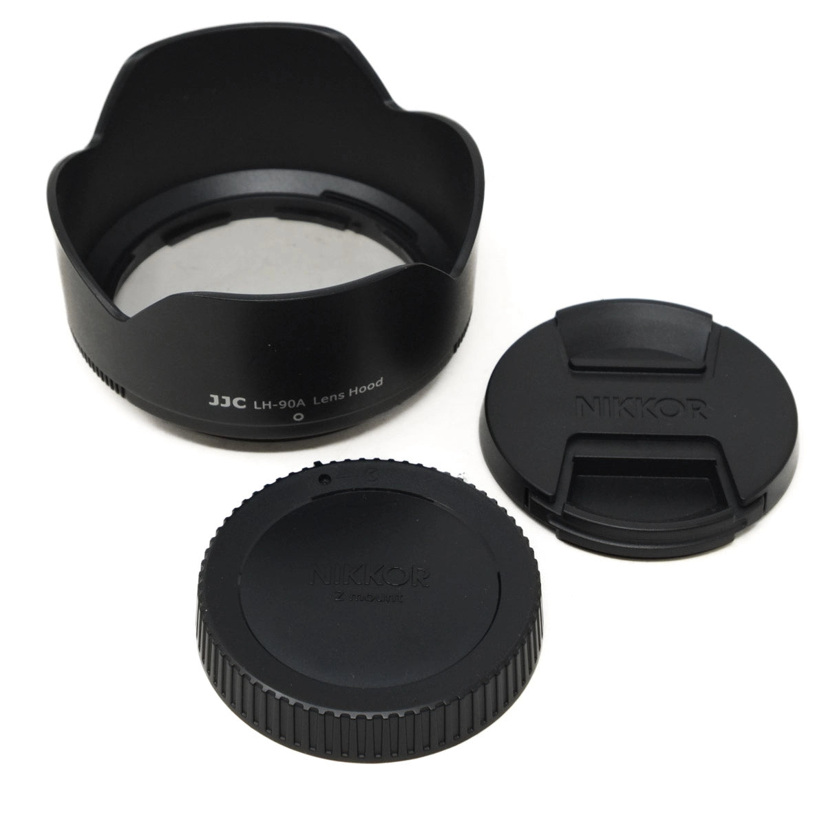 Camera lens hood, front cap, and rear cap on a white background