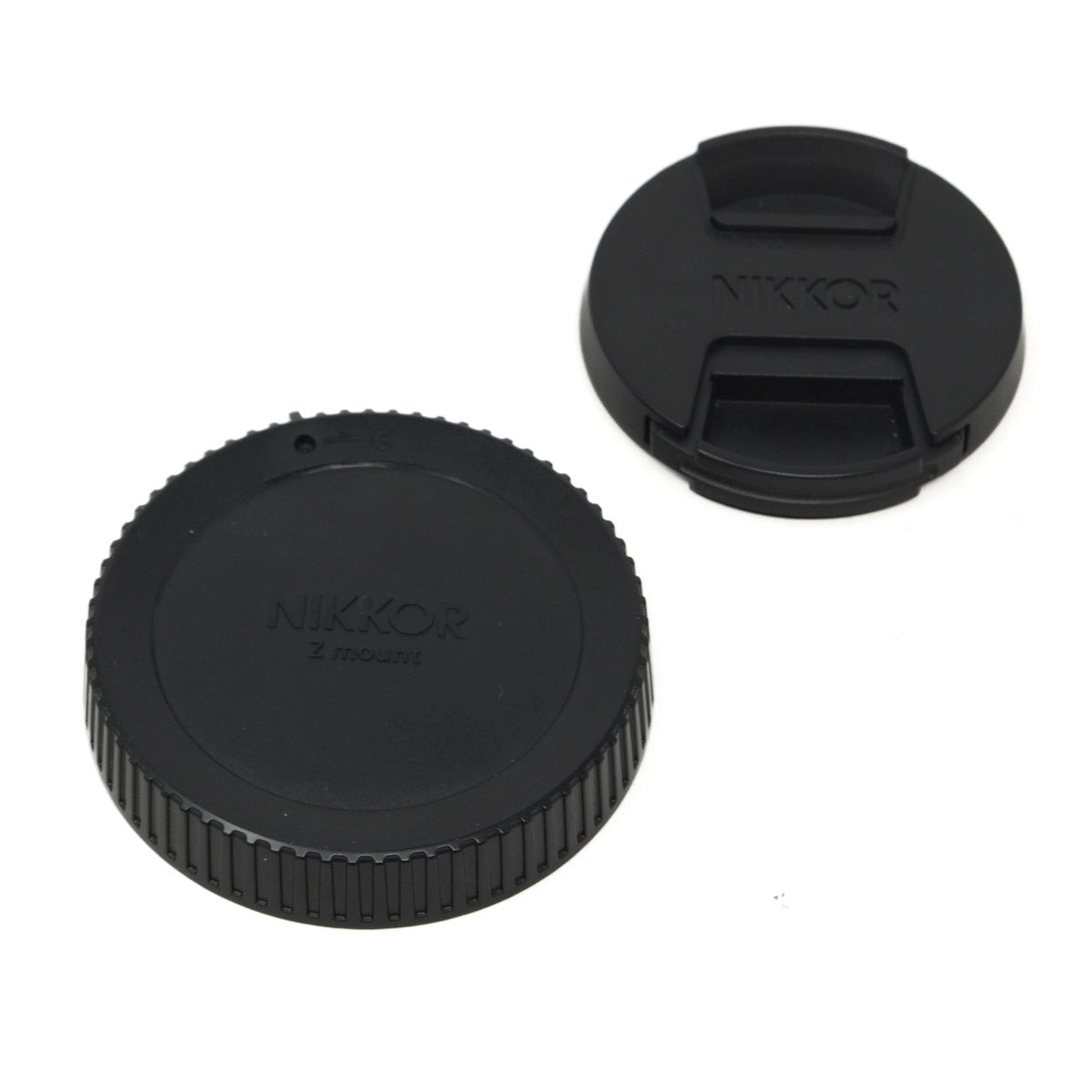 Two black Nikon lens caps on a white background