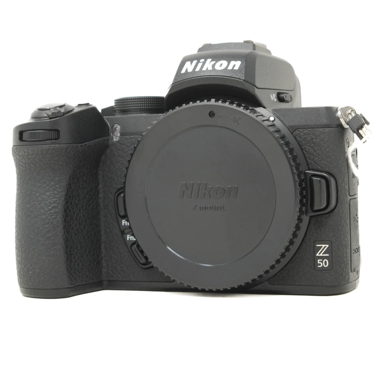 A Nikon Z 50 mirrorless camera body in black, shown from the front with the lens cap on, against a plain white background.