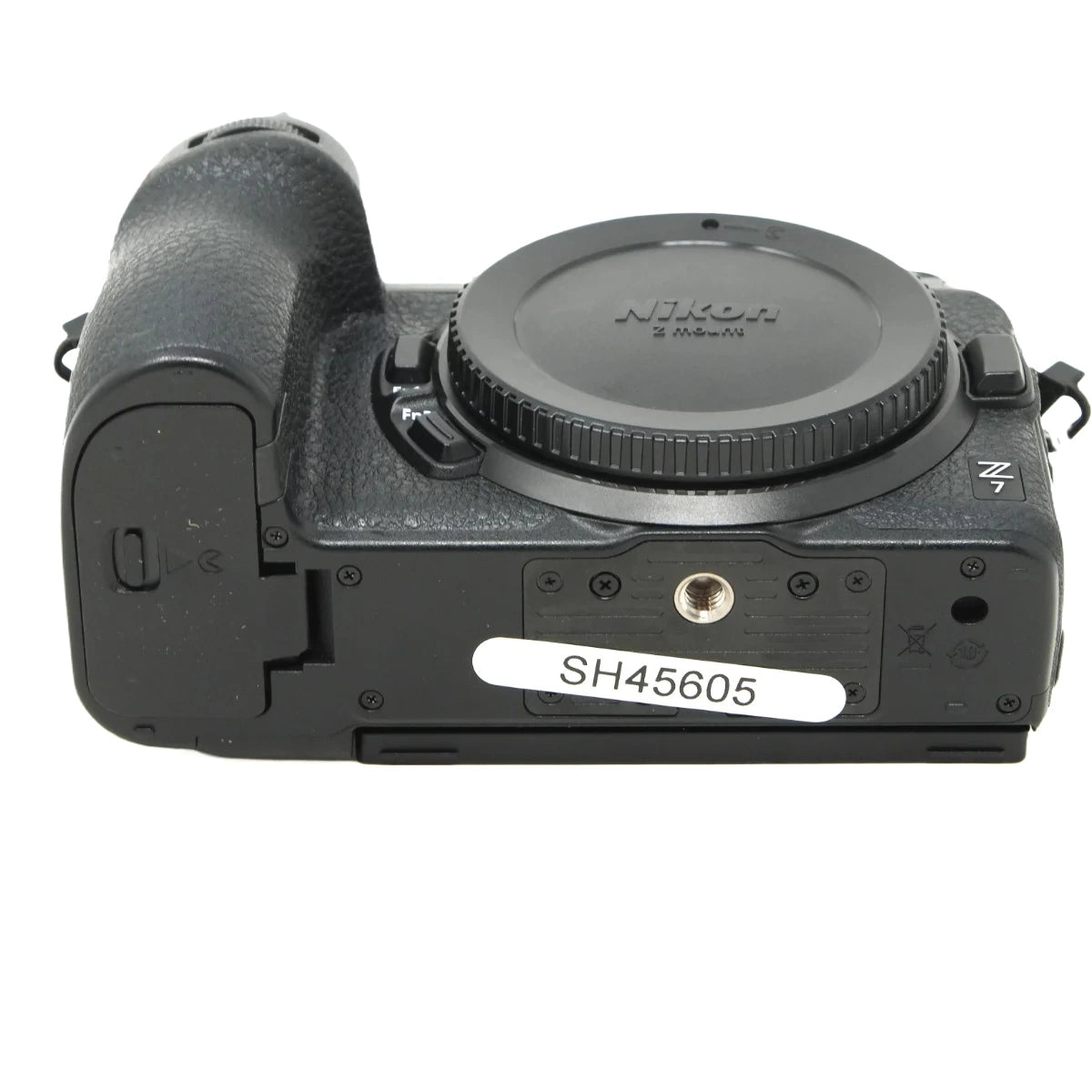 A black Nikon Z-Main mirrorless camera body with the lens cap removed, showing the Nikon branding and a white serial label sticker on the front.